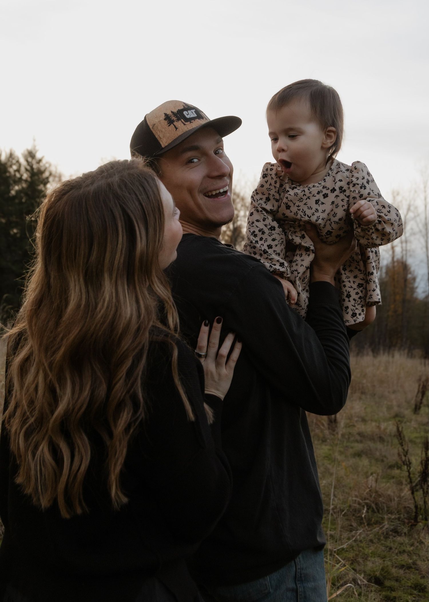 A candid family moment of joy and laughter captured in a rustic outdoor setting.