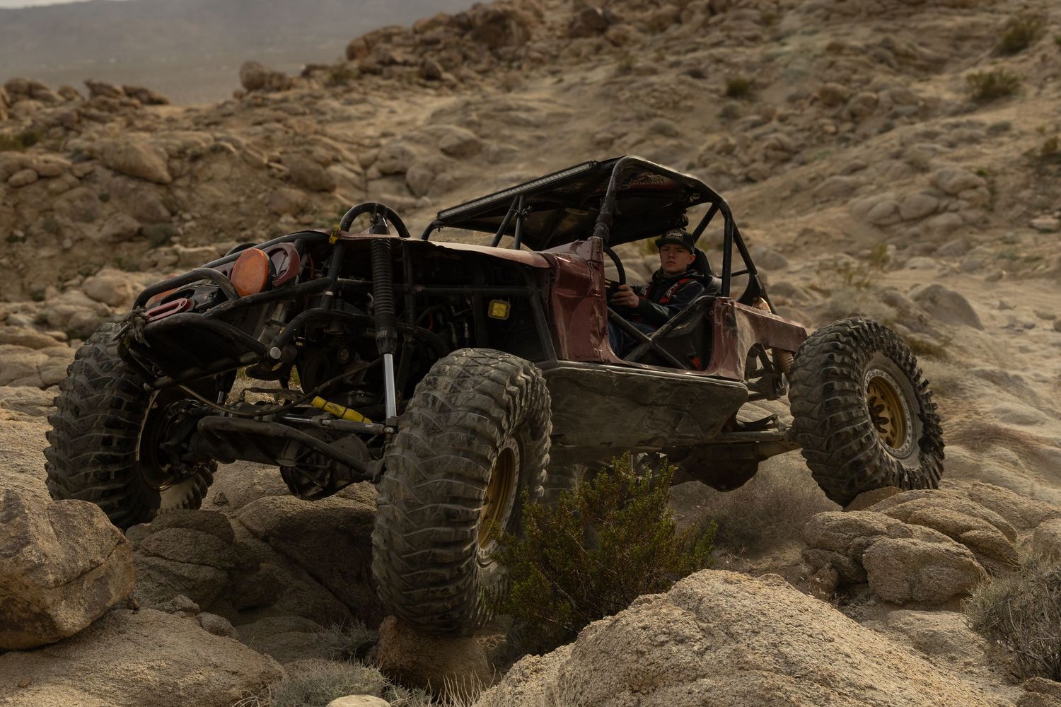 Off-road vehicle navigates challenging rocky terrain during an extreme rock crawling adventure.