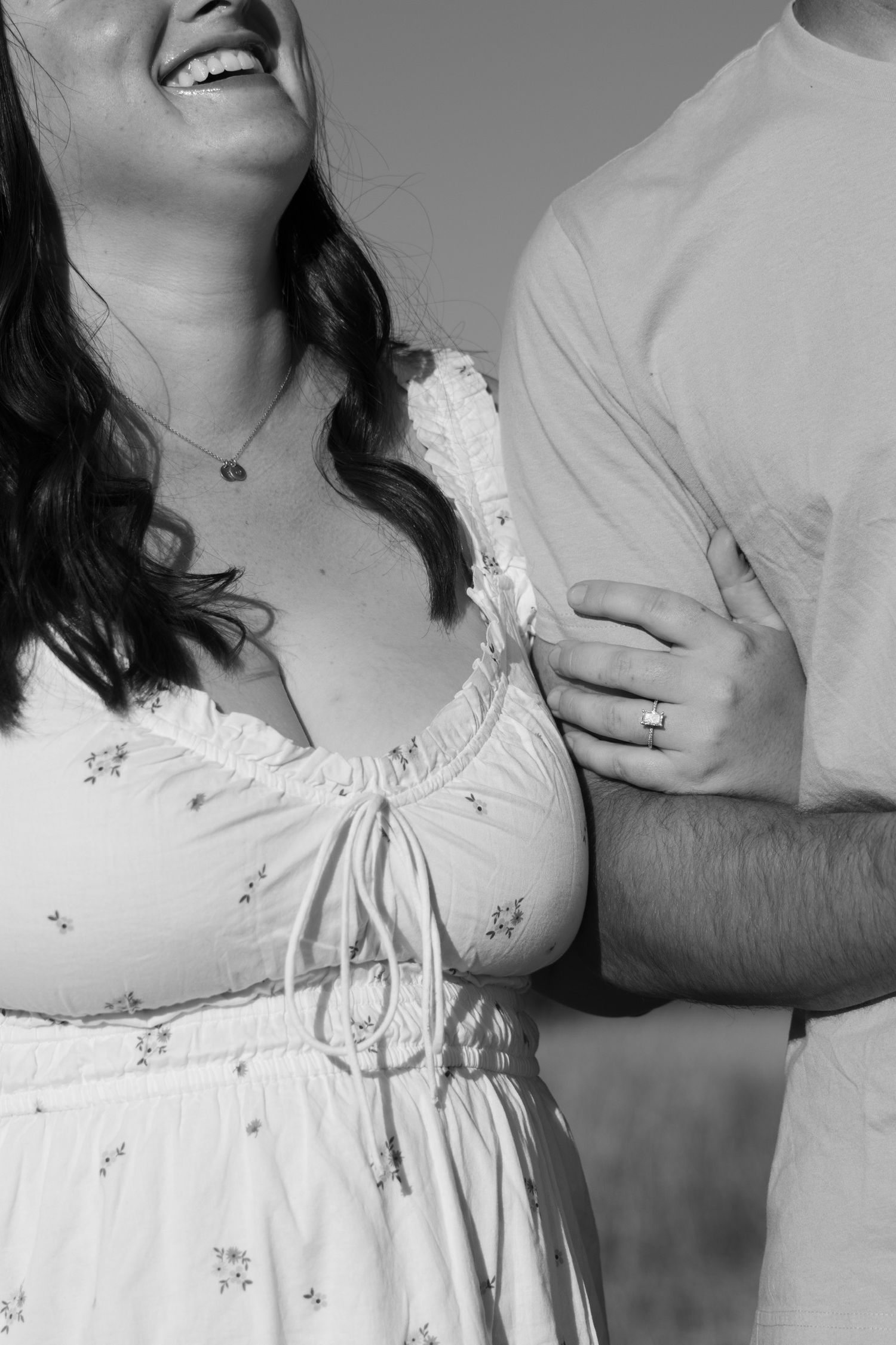 Couple wearing white clothing in intimate black and white portrait.