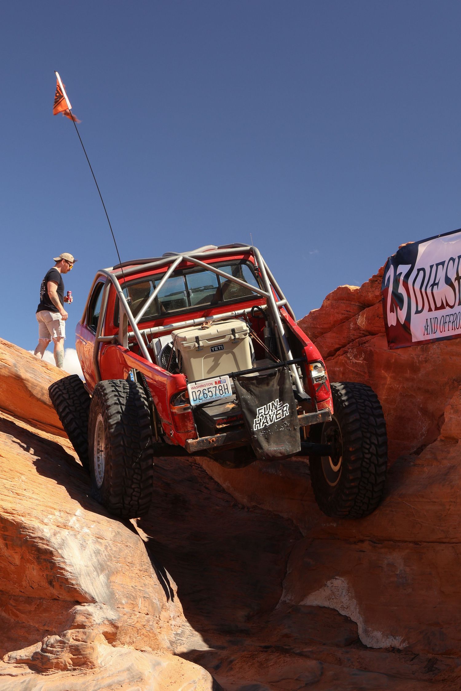 Off-road vehicle navigates challenging red rock terrain during an extreme desert adventure.
