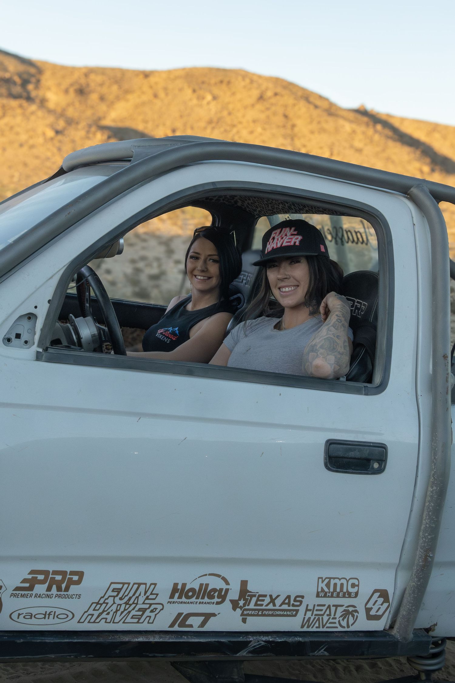 Small aircraft cockpit with occupants shown during golden hour against desert mountain backdrop.