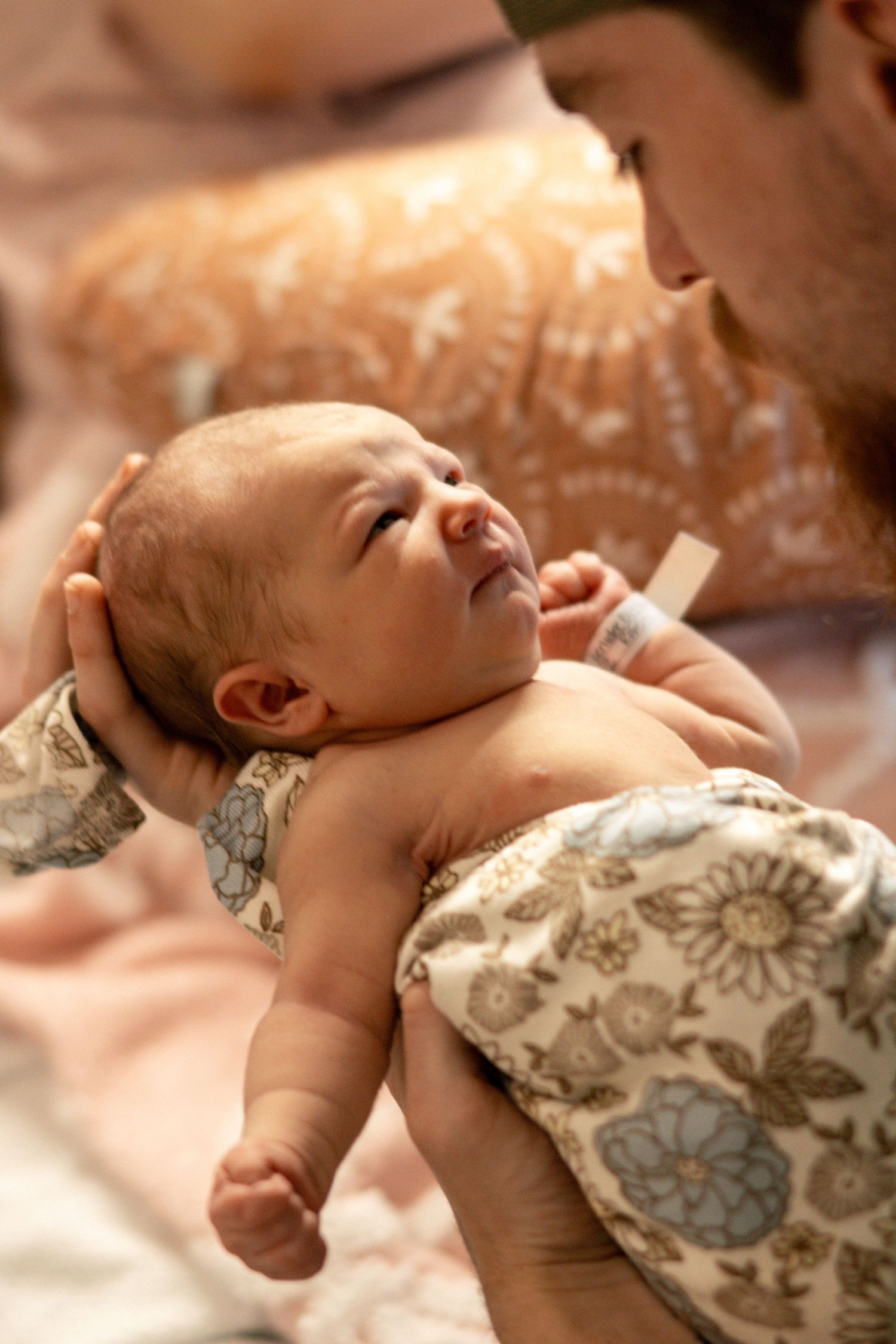 Newborn baby wrapped in hospital blanket during Fresh 48 session
