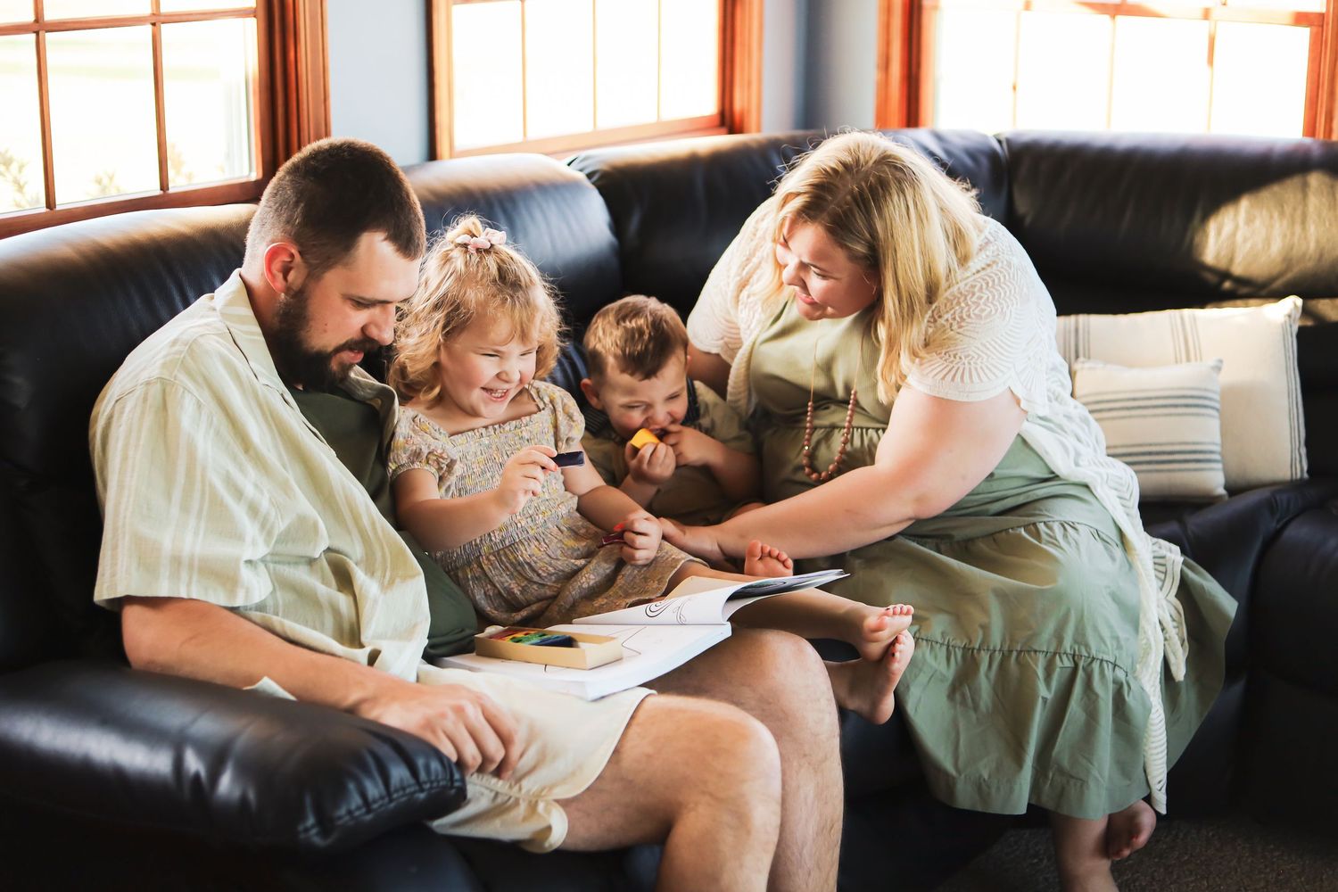 Family relaxing together on a leather couch in a cozy living room.