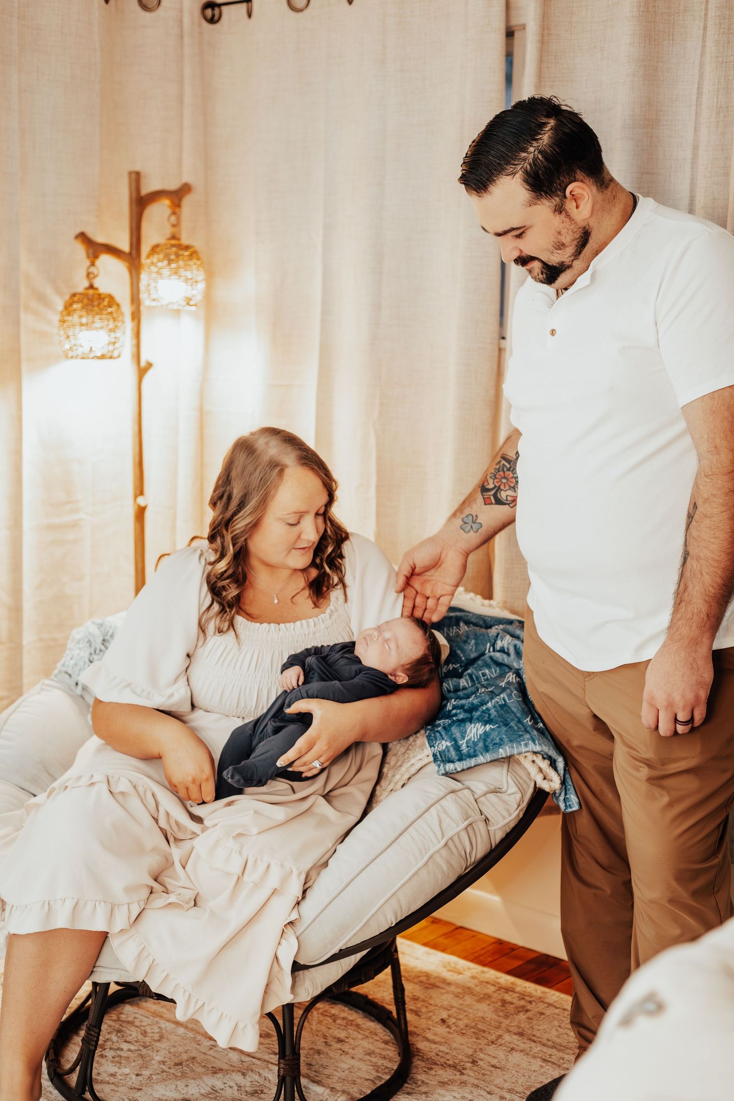 Intimate family moments captured in a warmly lit room with white curtains.