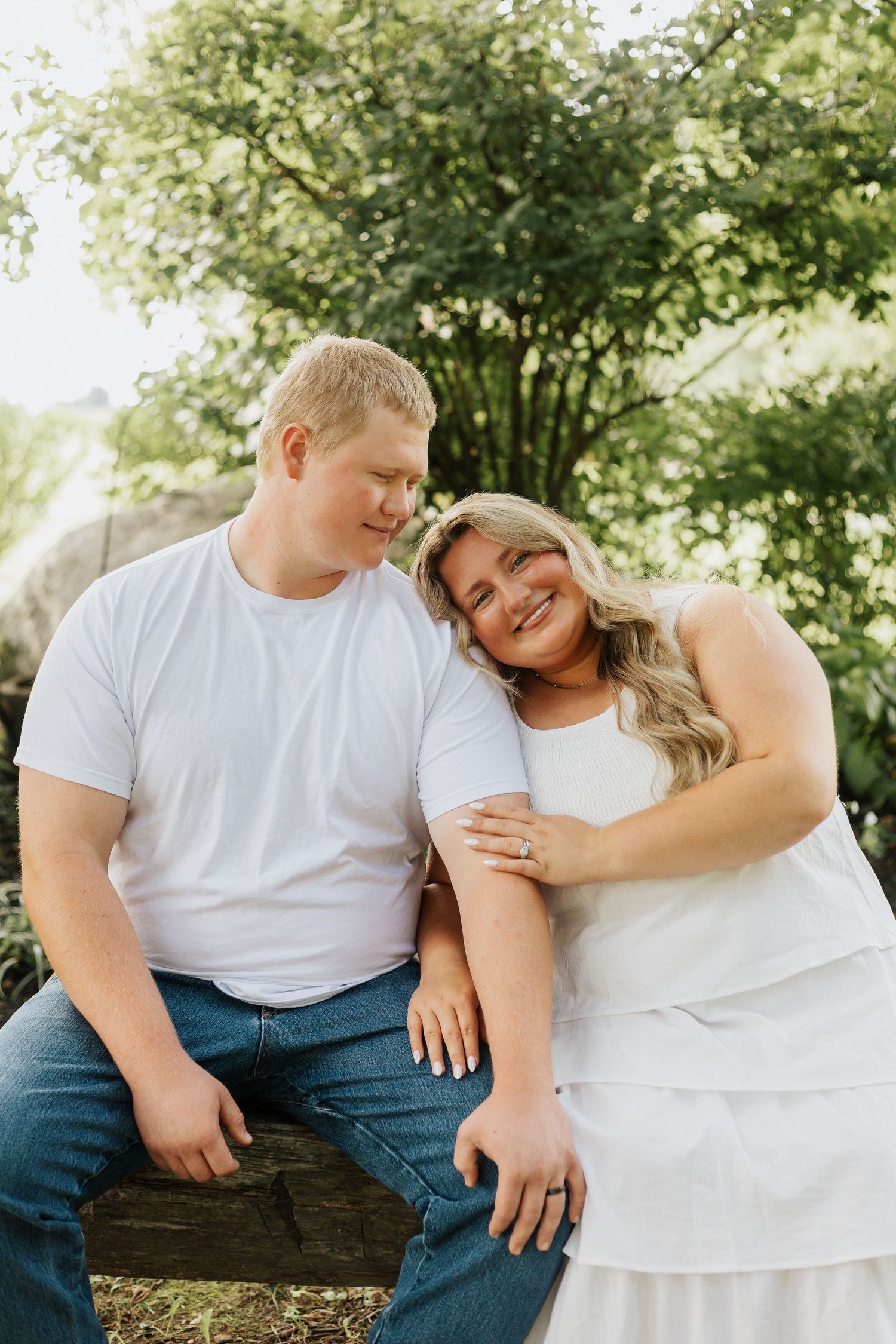 A couple shares tender moments while sitting together outdoors.