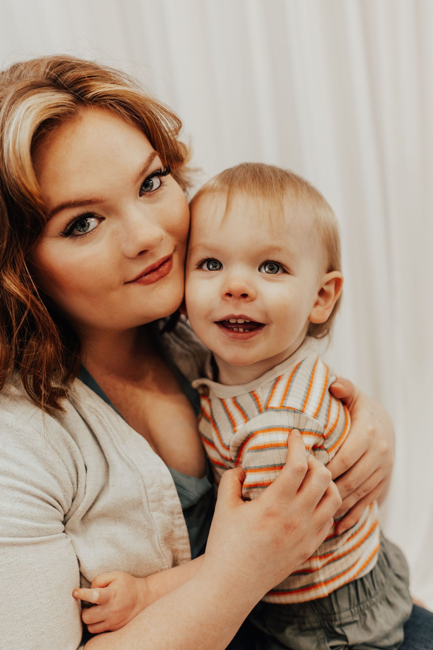 A heartwarming indoor portrait of parent and baby sharing a joyful moment.