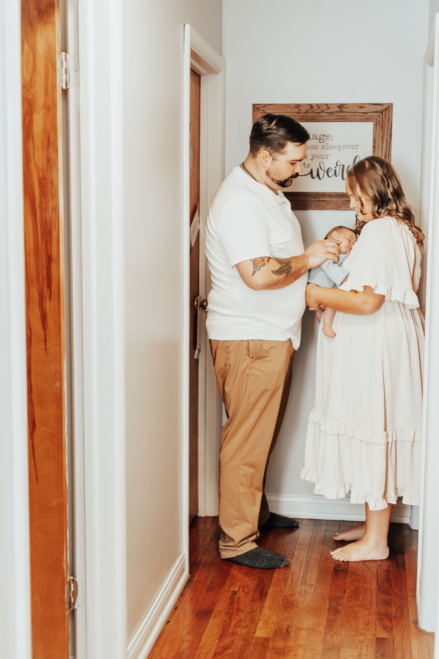 Family sharing special moments together in a white-walled hallway.