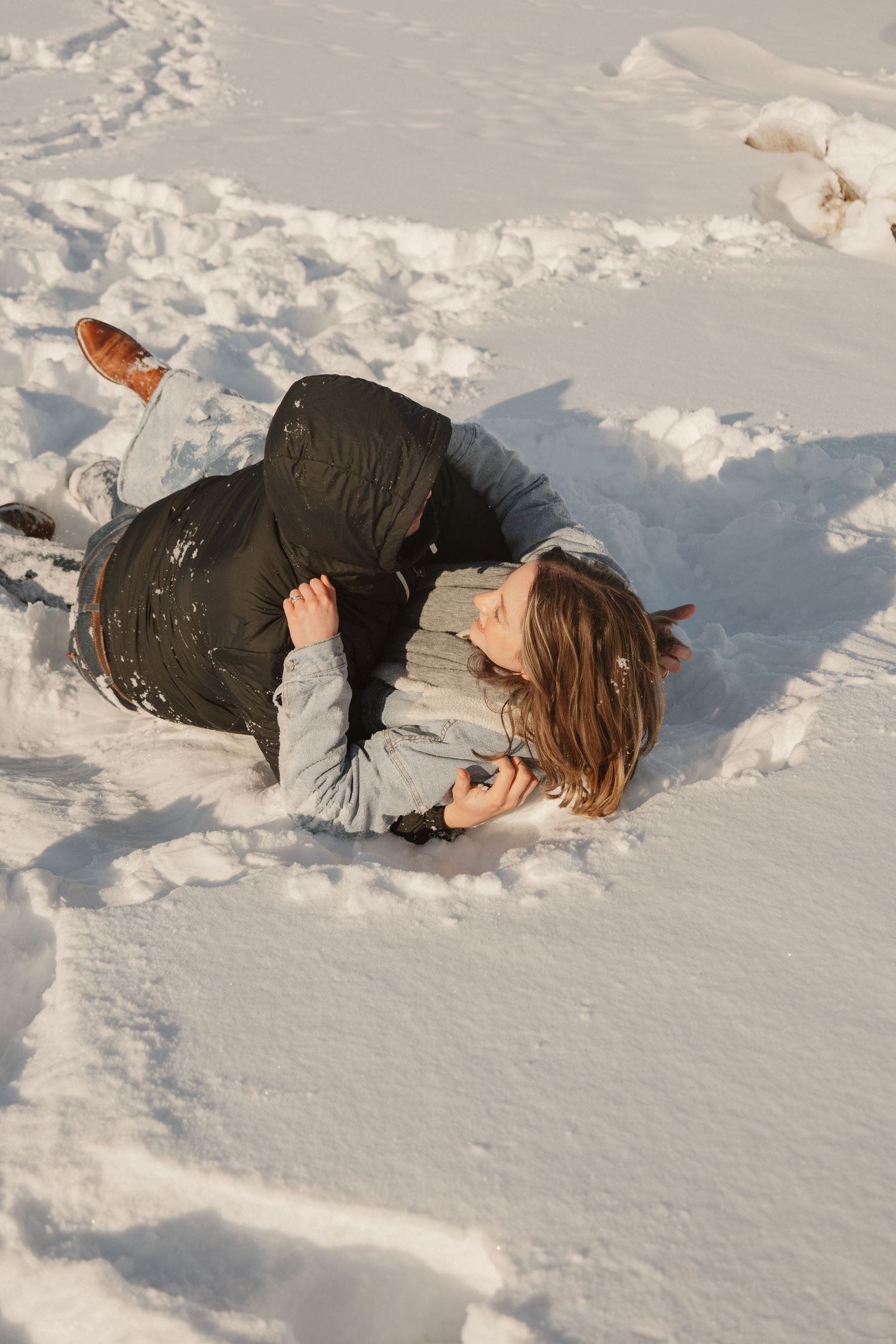 A romantic moment captured while lying in fresh snow during winter.