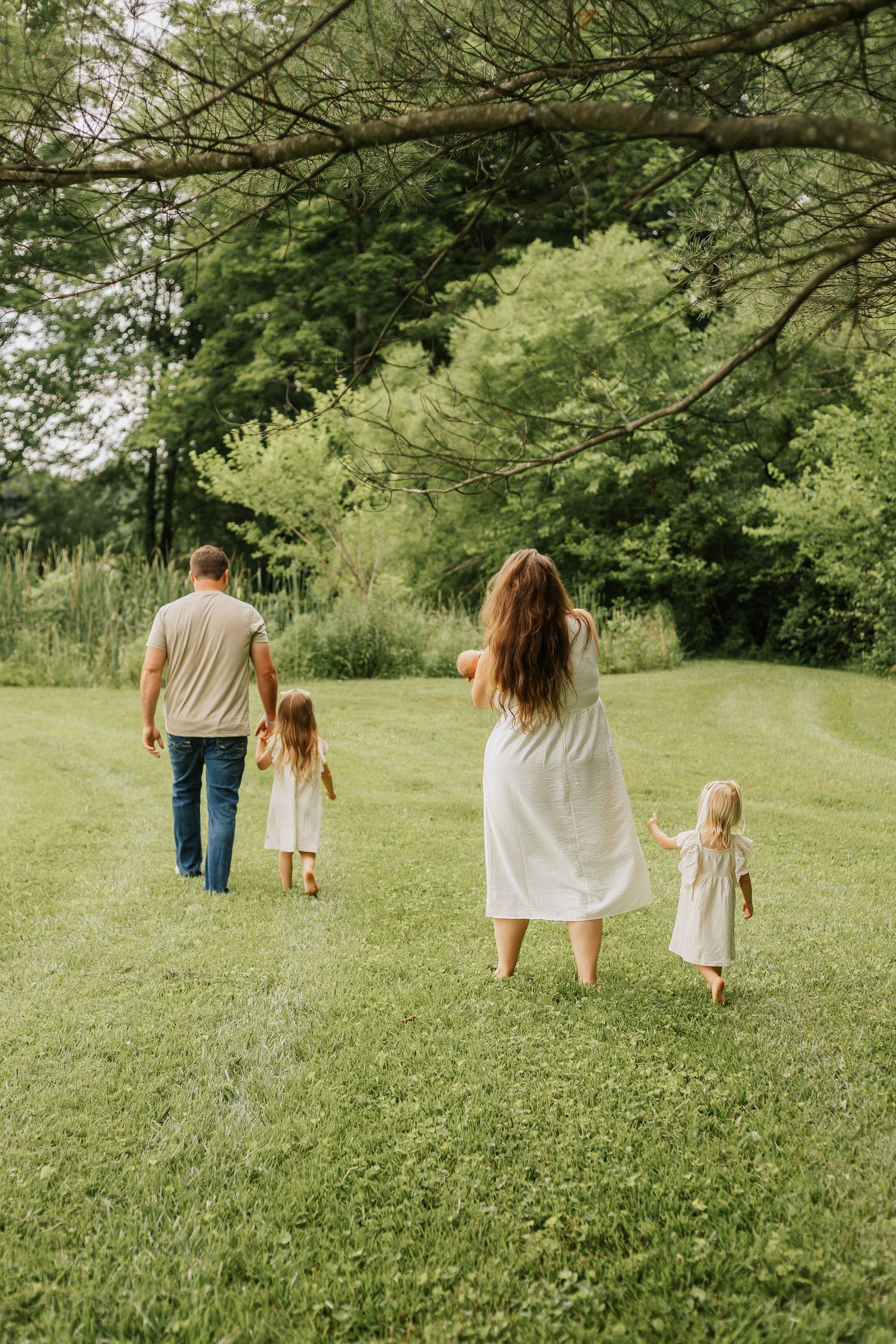 Family walking together through a lush green park on a summer day.