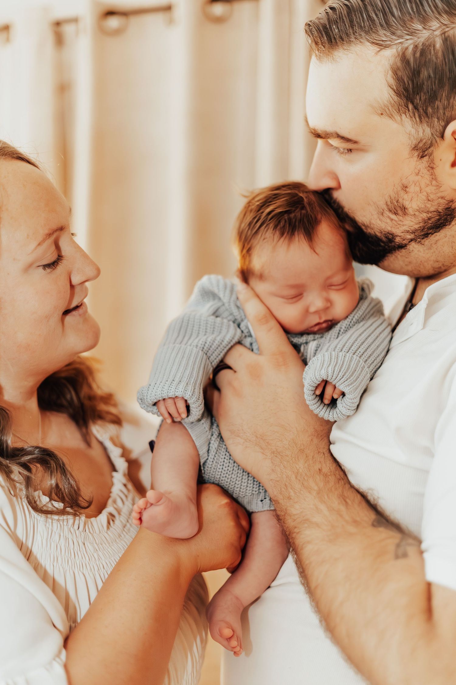 Intimate family bonding moments with baby in soft indoor lighting.