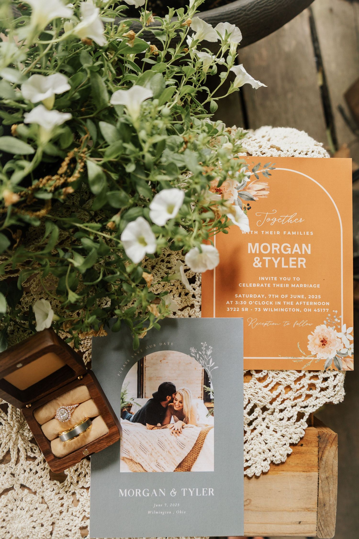 Wedding invitations in terracotta colors styled with white flowers and vintage decor on lace.