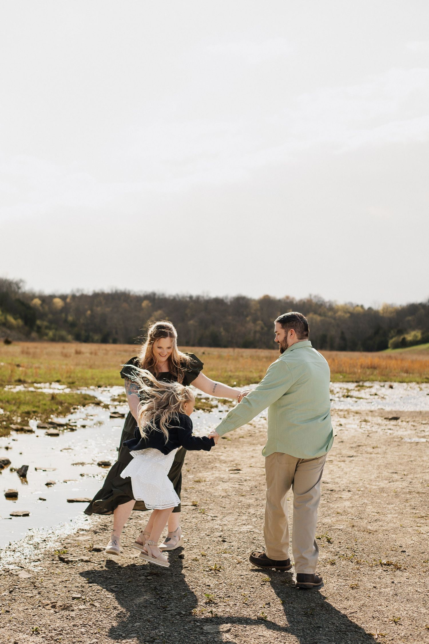 Couple dancing together on a dirt path with autumn fields in the background.