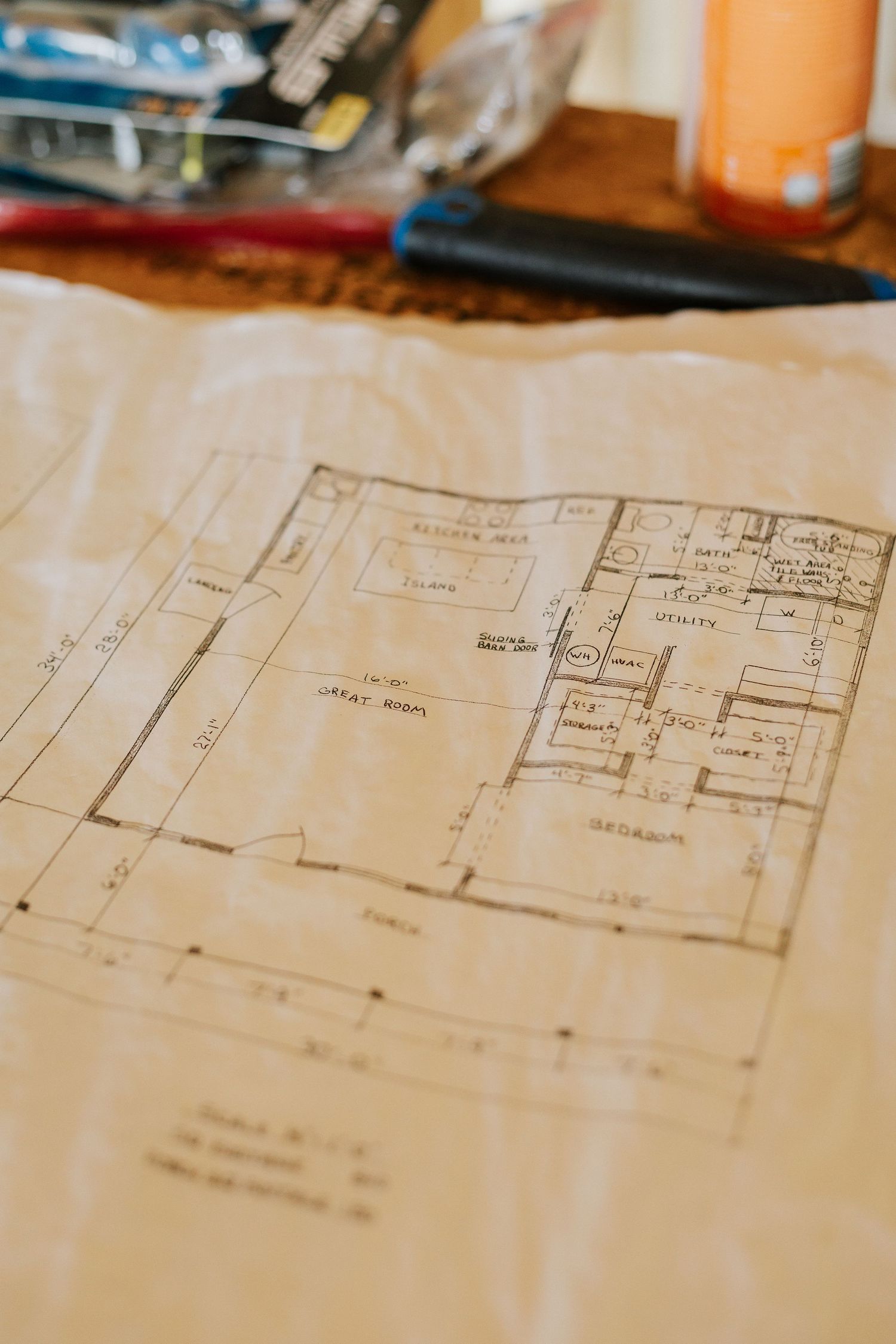 Architectural blueprints and floor plans laid out on construction site surface.