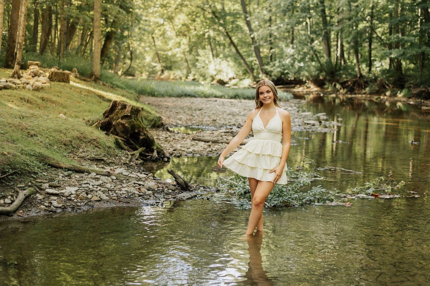A carefree summer photoshoot by a peaceful creek with natural stone features.