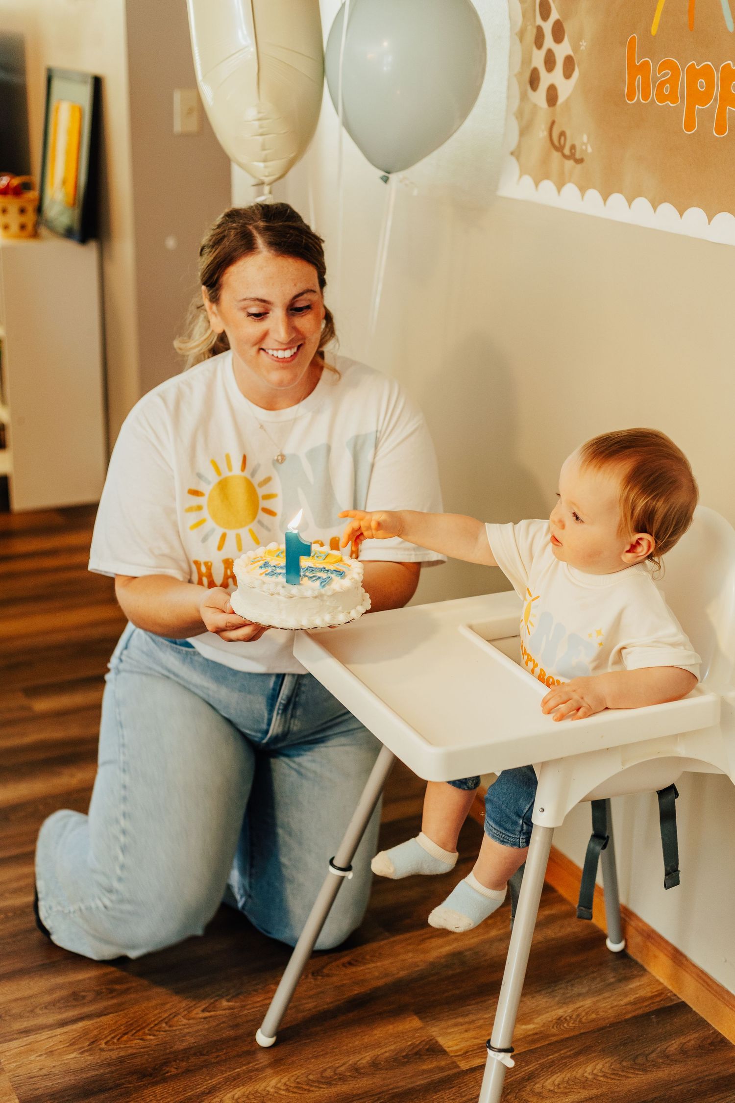 First birthday celebration with baby in high chair and festive decorations.