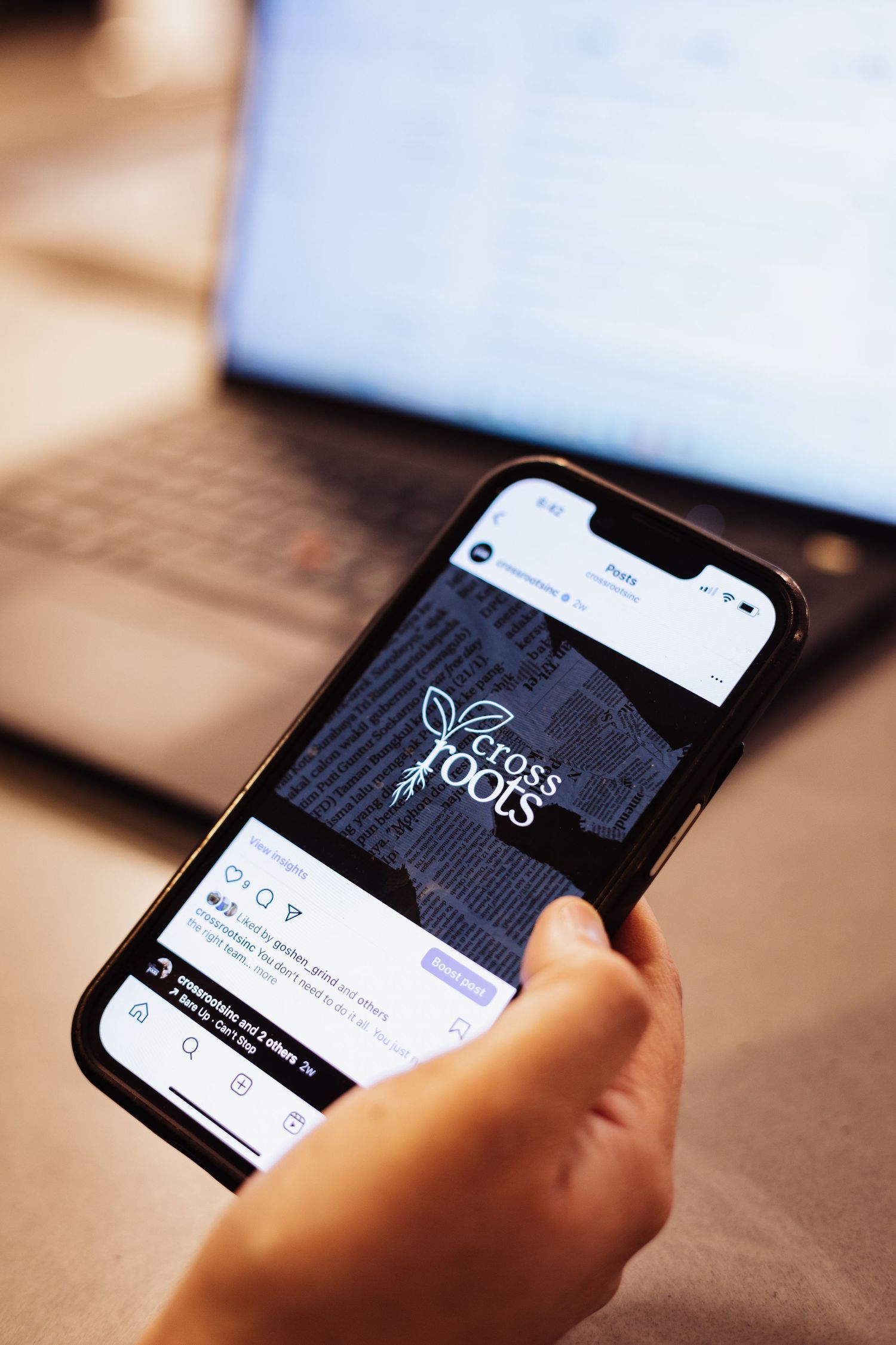 Mobile phone displaying company social media profile and branding.