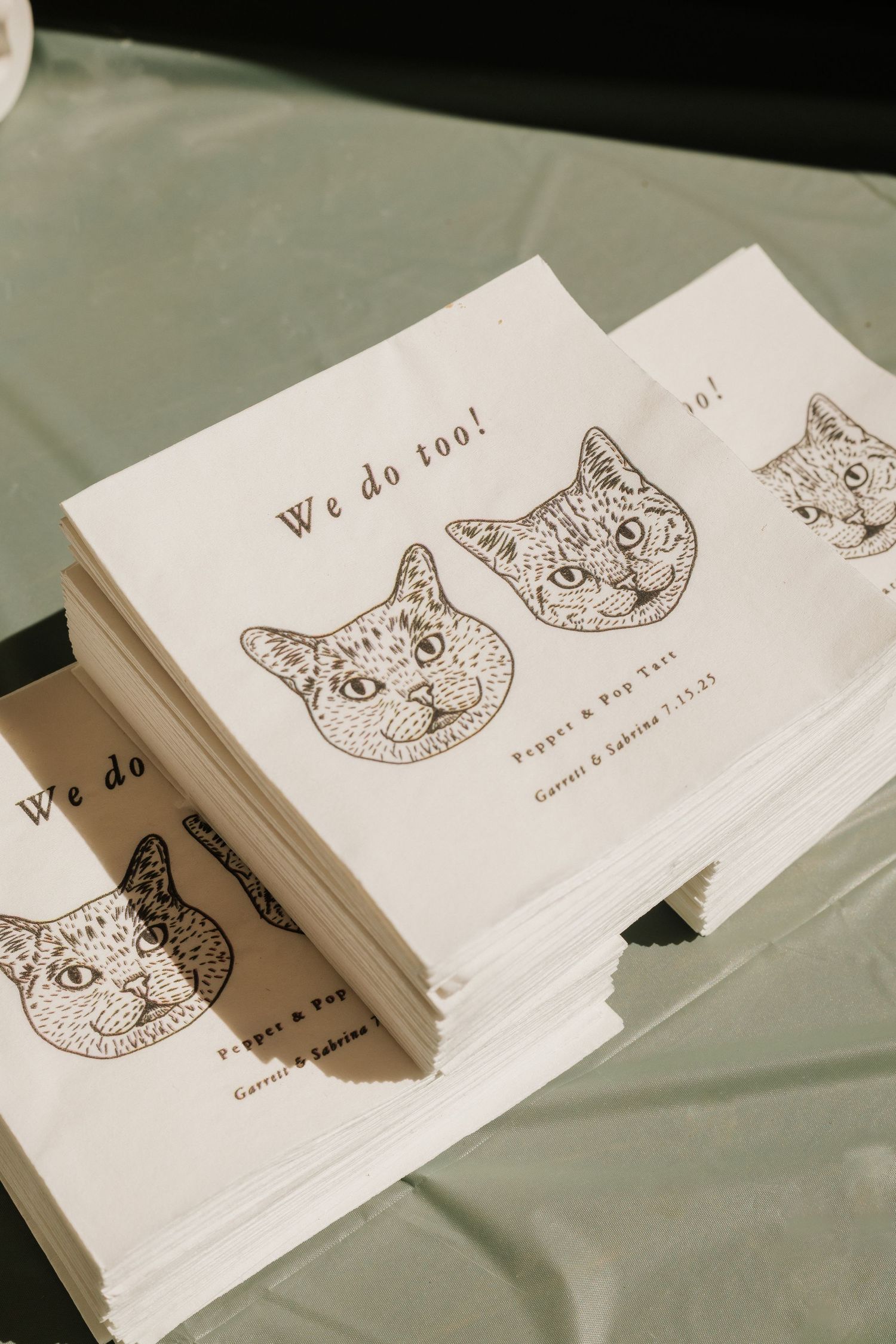 Wedding invitation cards featuring delicate cat illustrations in brown ink on white paper.