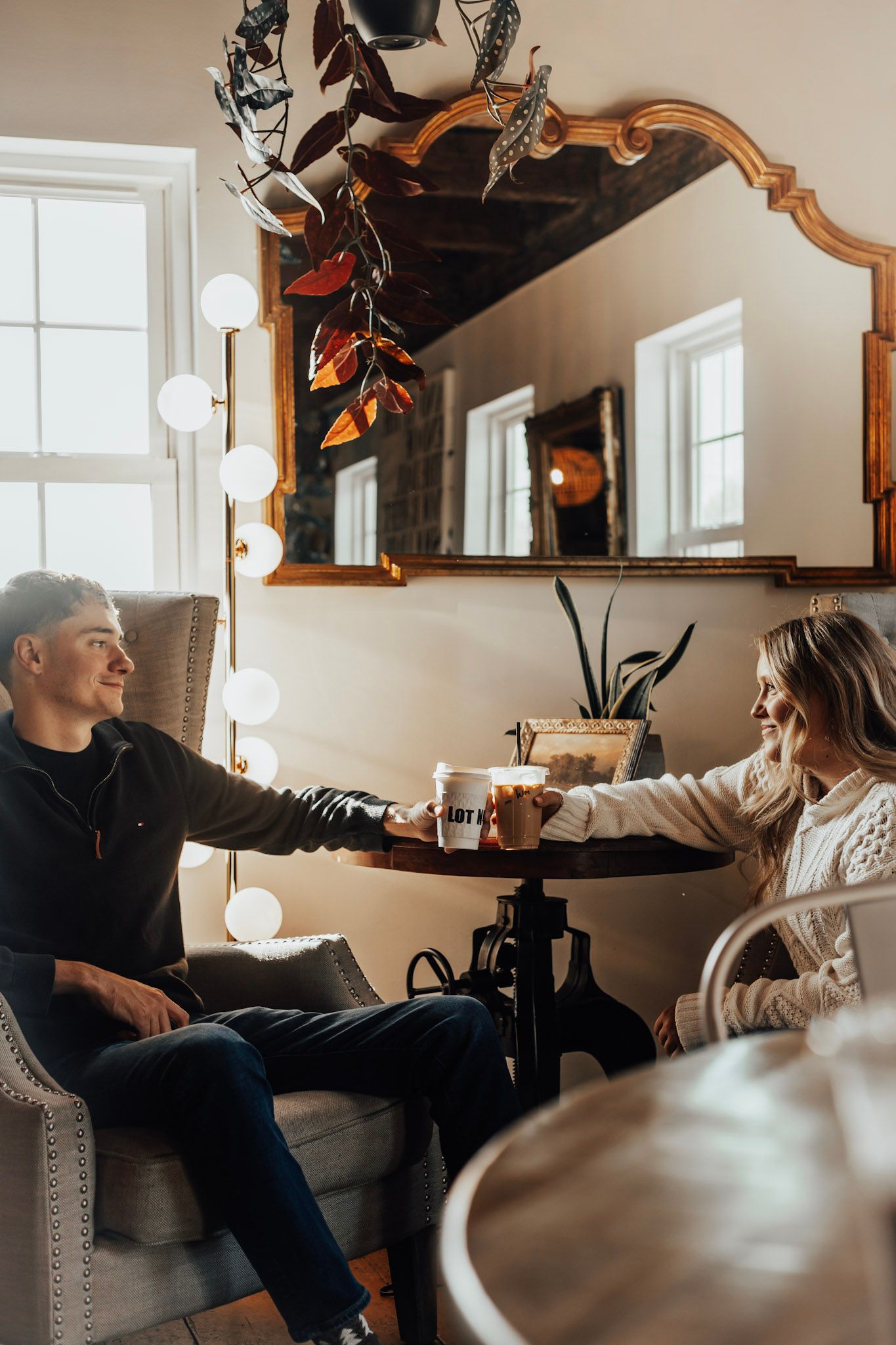 Couple shares intimate conversation while relaxing on white couch in cozy living room with natural lighting.