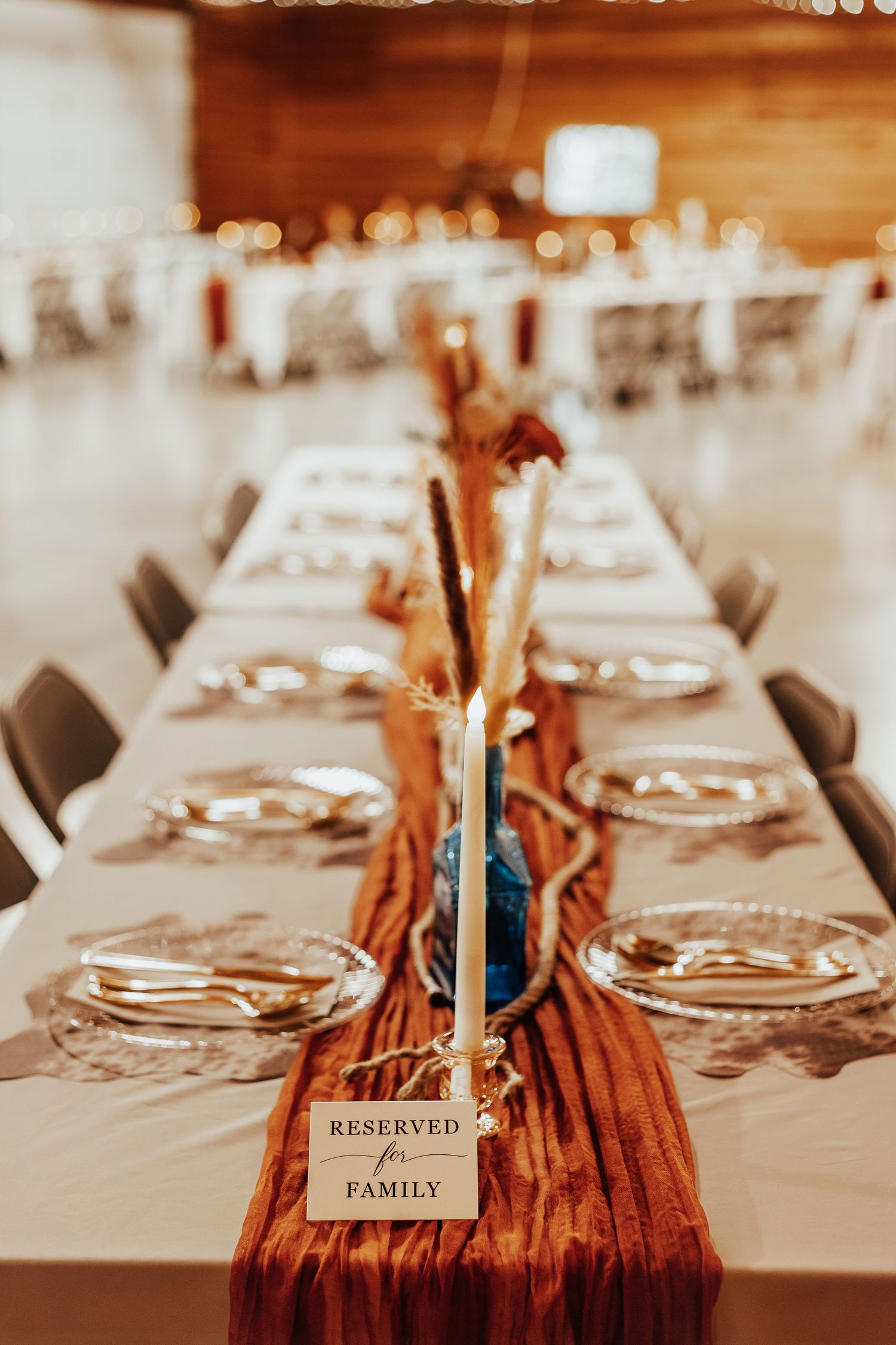Wedding reception table settings with reserved family place cards and elegant dinnerware.