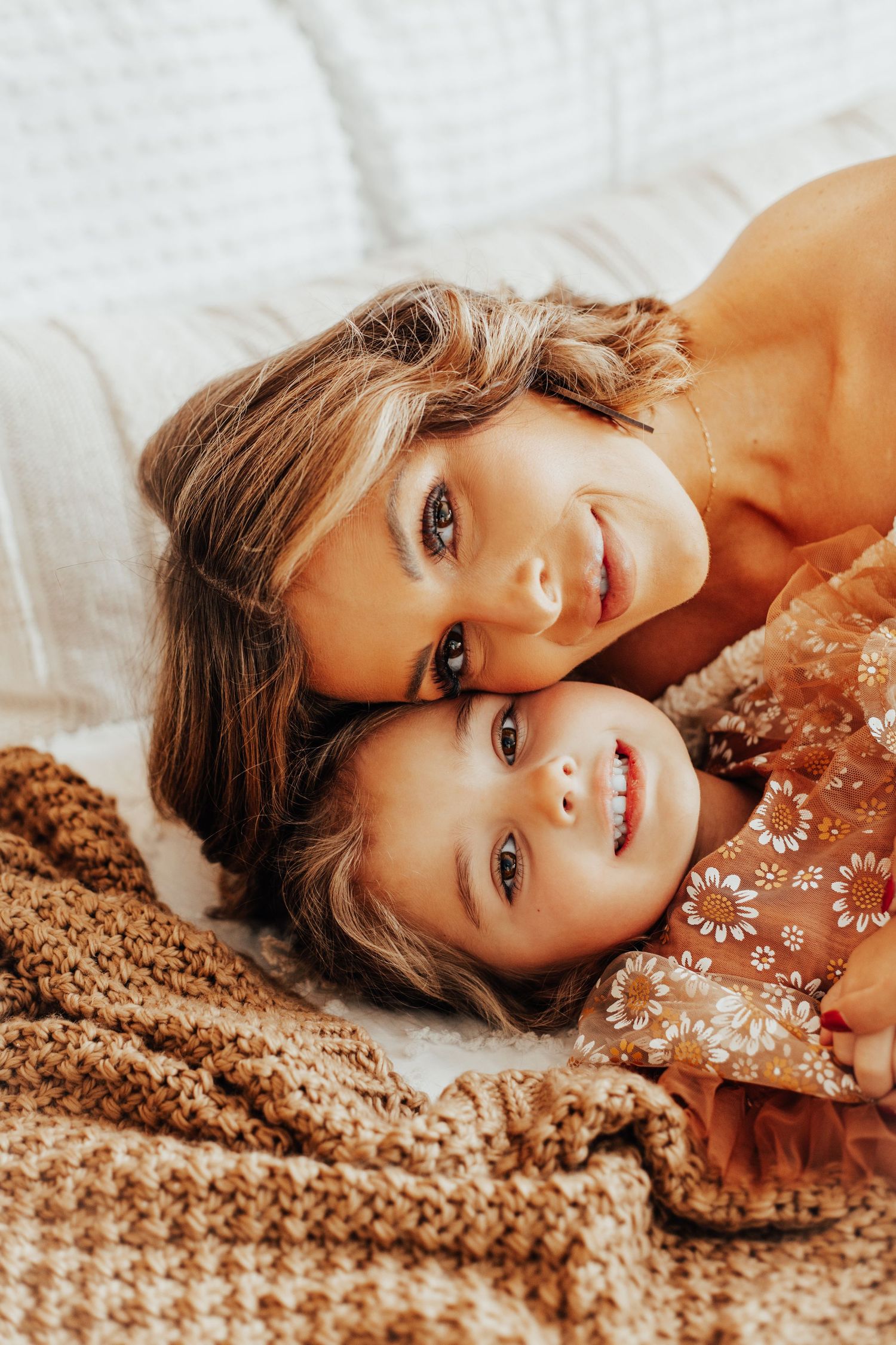 Lifestyle portrait session on white bedding with sparkly dress details.