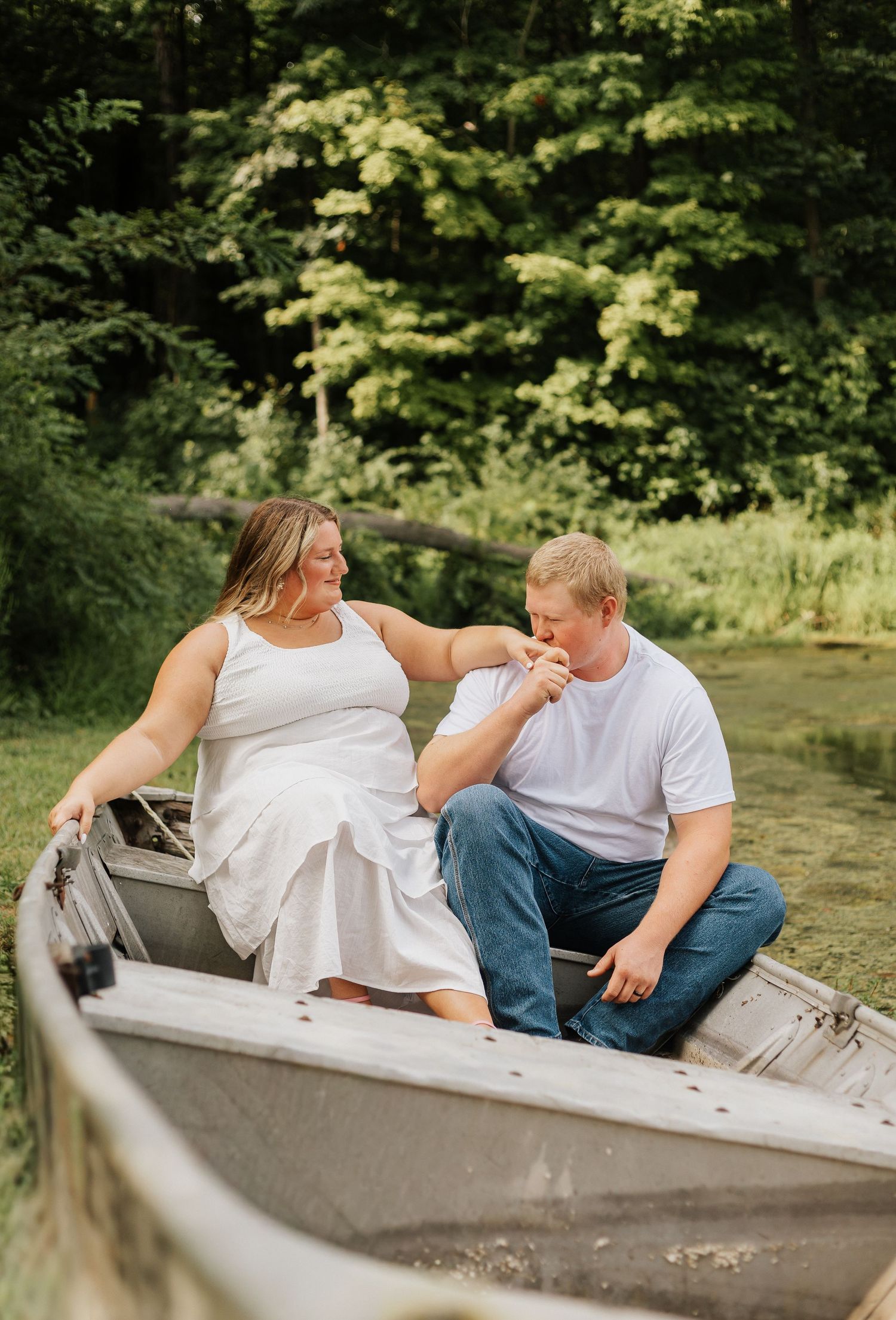 A couple shares intimate moments while sitting in a rowboat.