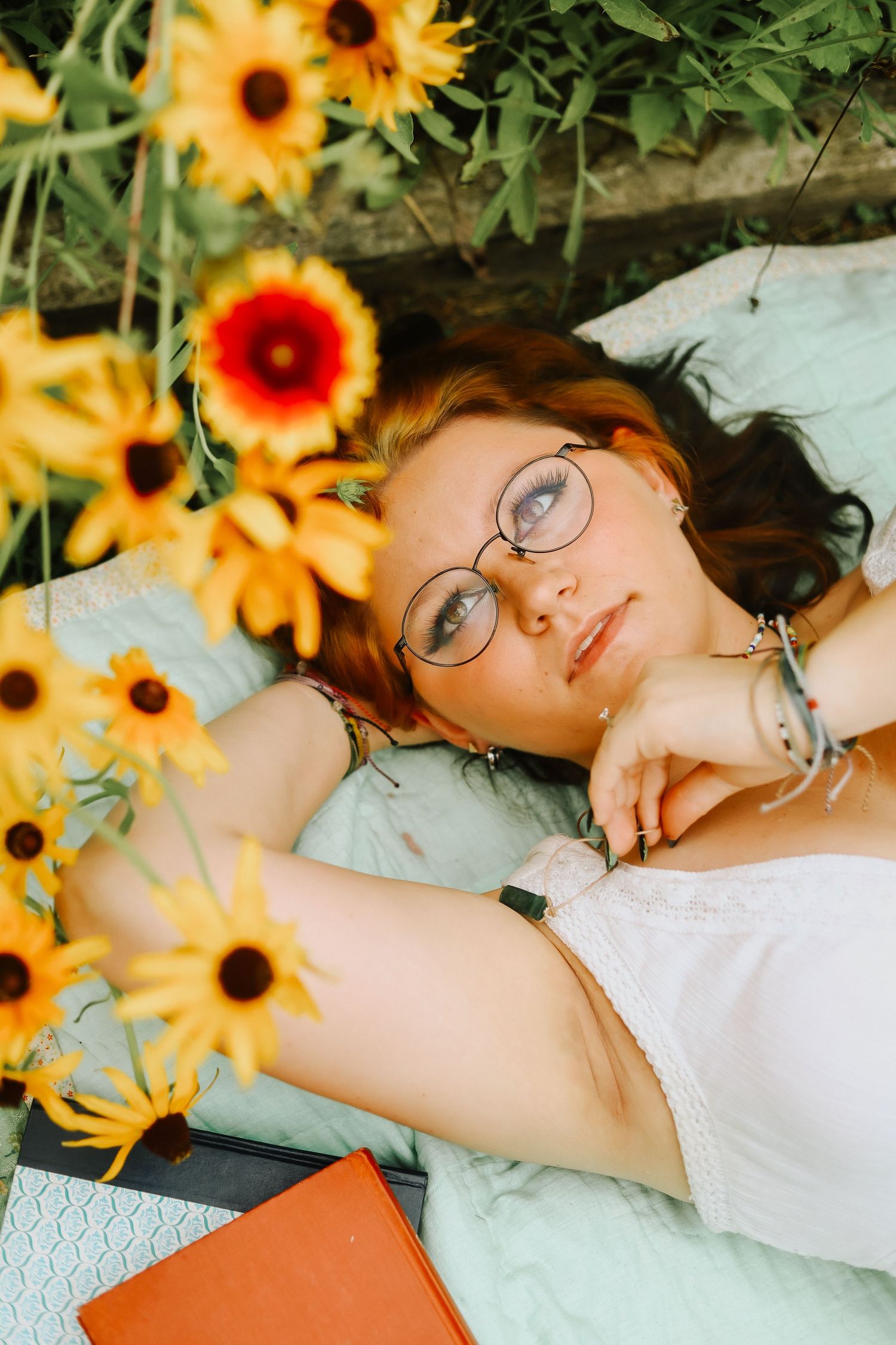 Bright sunflowers frame a dreamy summer reading scene with books and blankets.