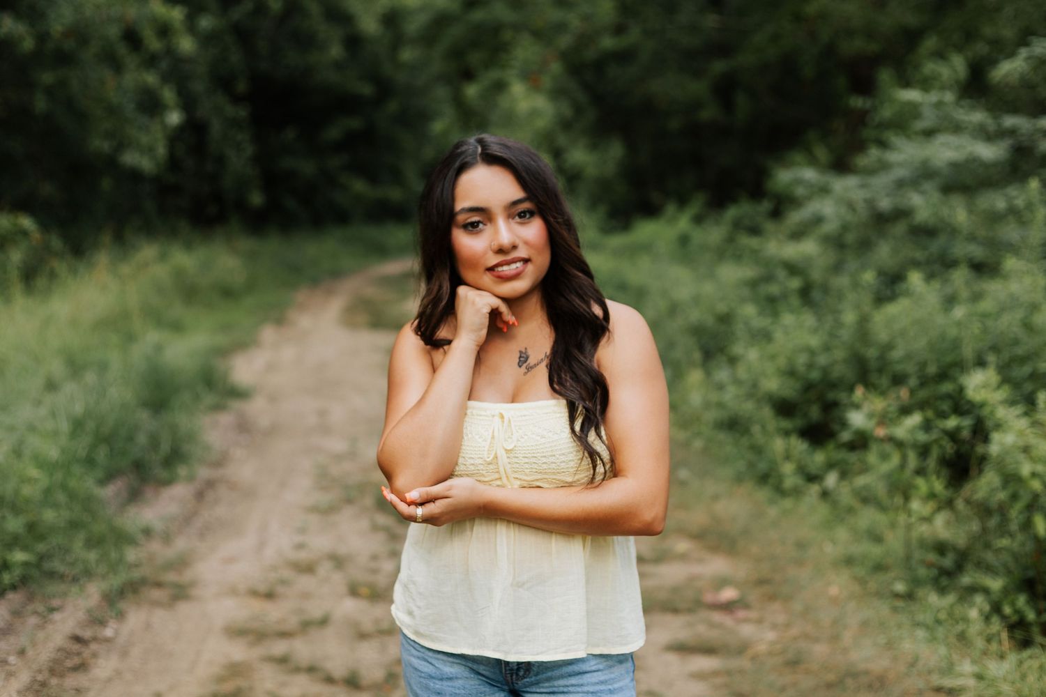 Natural outdoor portrait session along a wooded path with casual summer attire.