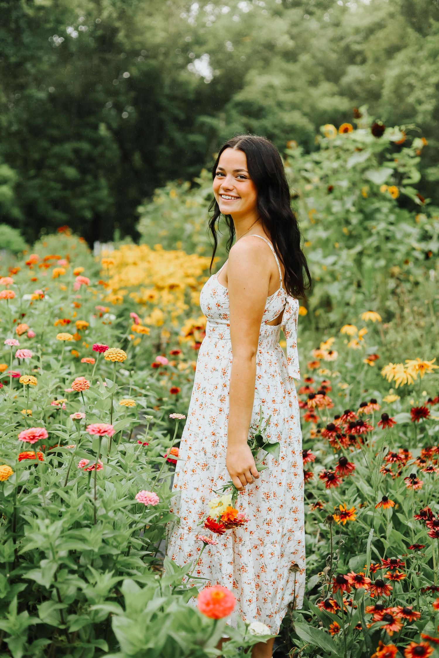 A floral summer photoshoot in a garden with vibrant orange and yellow blooms against lush greenery.