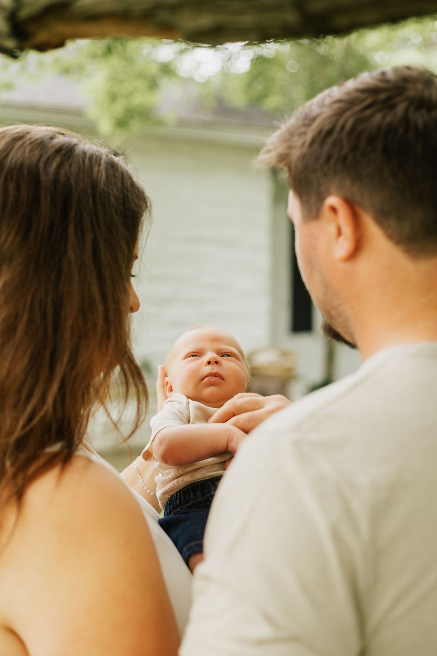 Intimate family moment captured outdoors in soft natural lighting.
