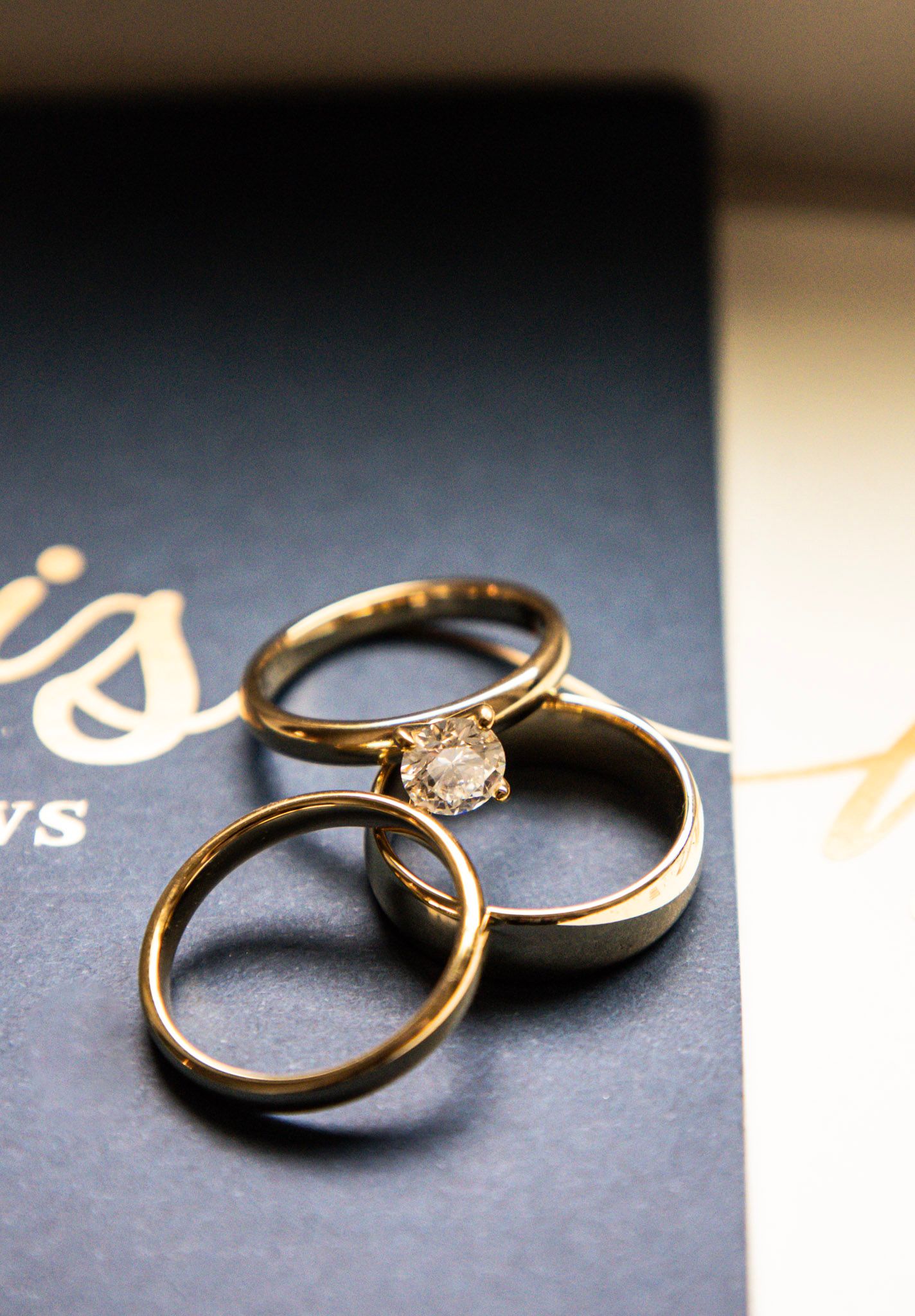Two gold wedding rings photographed on a dark background with elegant text.