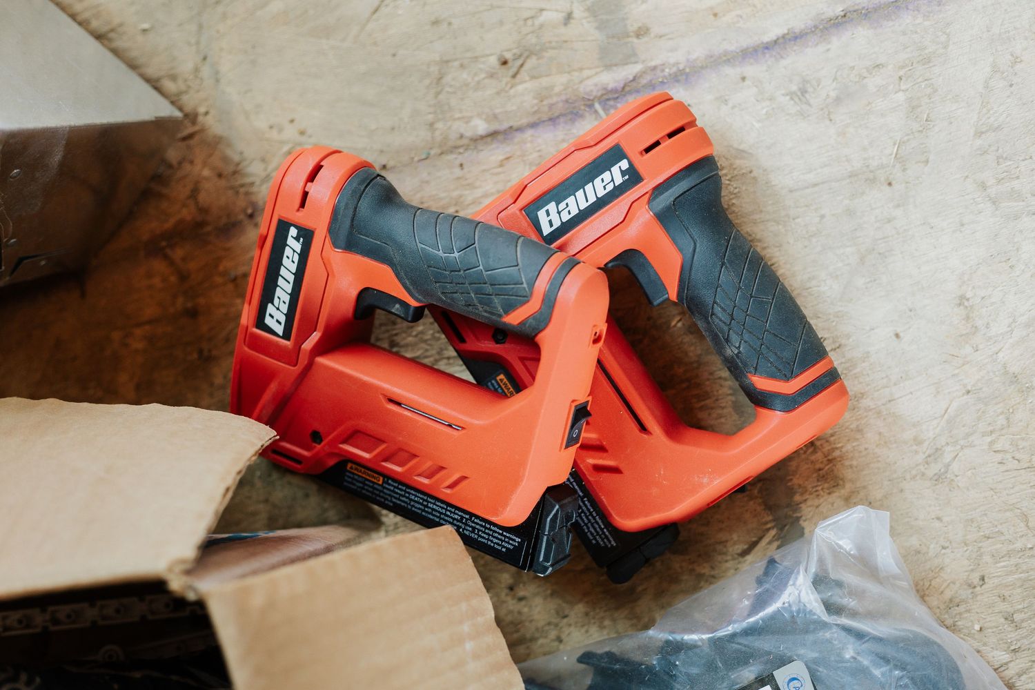 Orange power tools and construction equipment arranged on concrete floor.