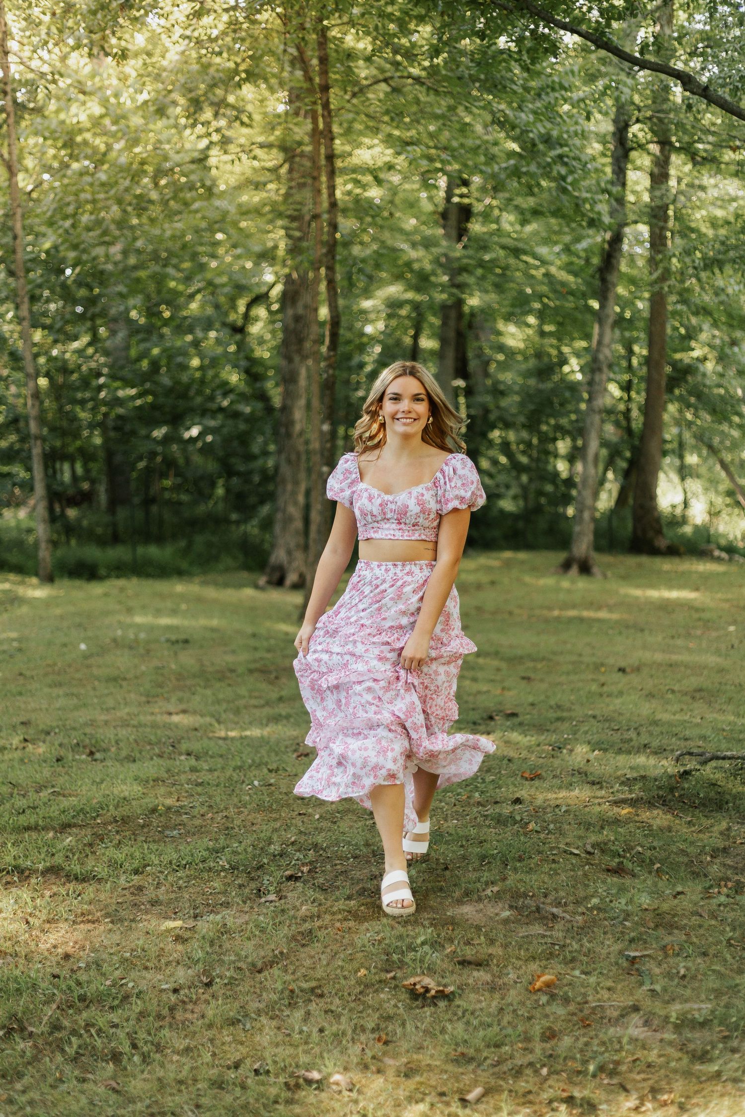 A dynamic outdoor photo series featuring a pink floral dress in a sunlit forest setting.