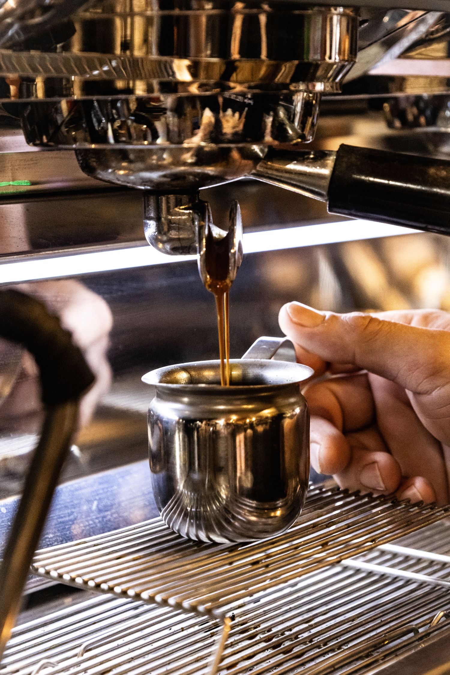 Close-up shot of an espresso machine dispensing coffee into a cup.