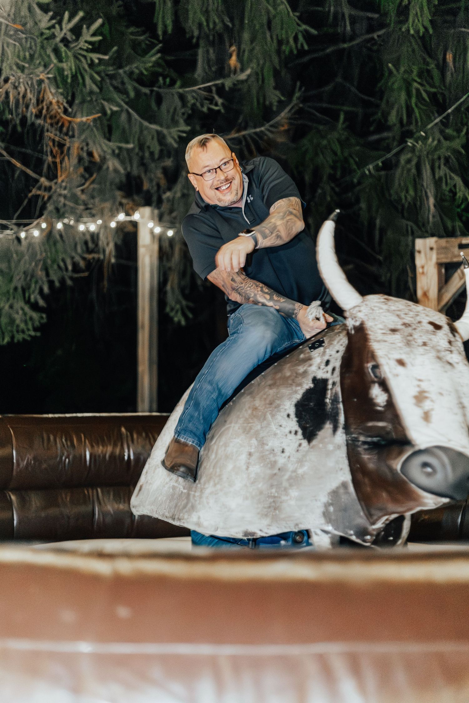 Person riding a mechanical bull at what appears to be a wedding reception or party.