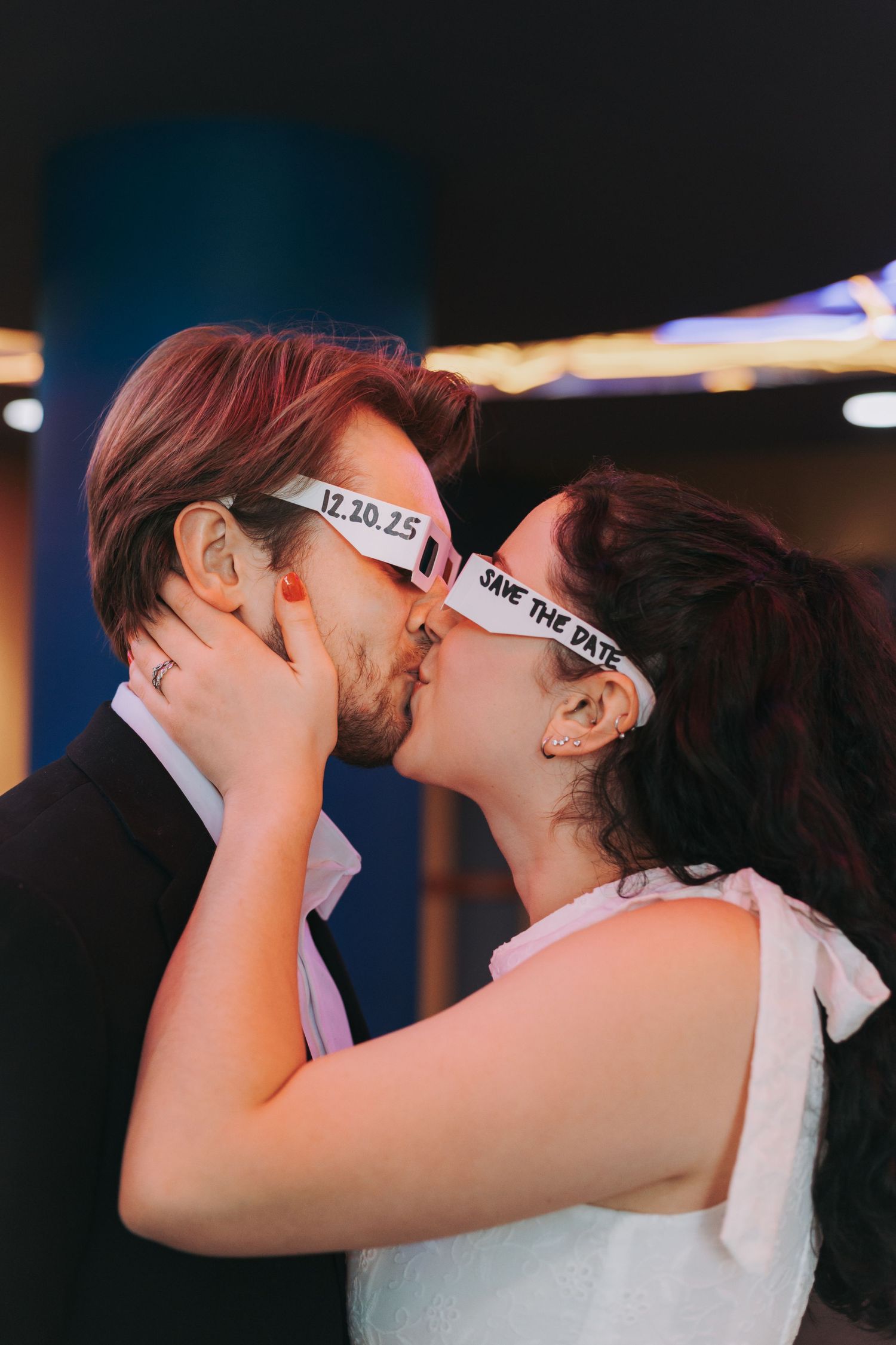 Couple sharing an intimate moment with blindfolds in a dimly lit setting.