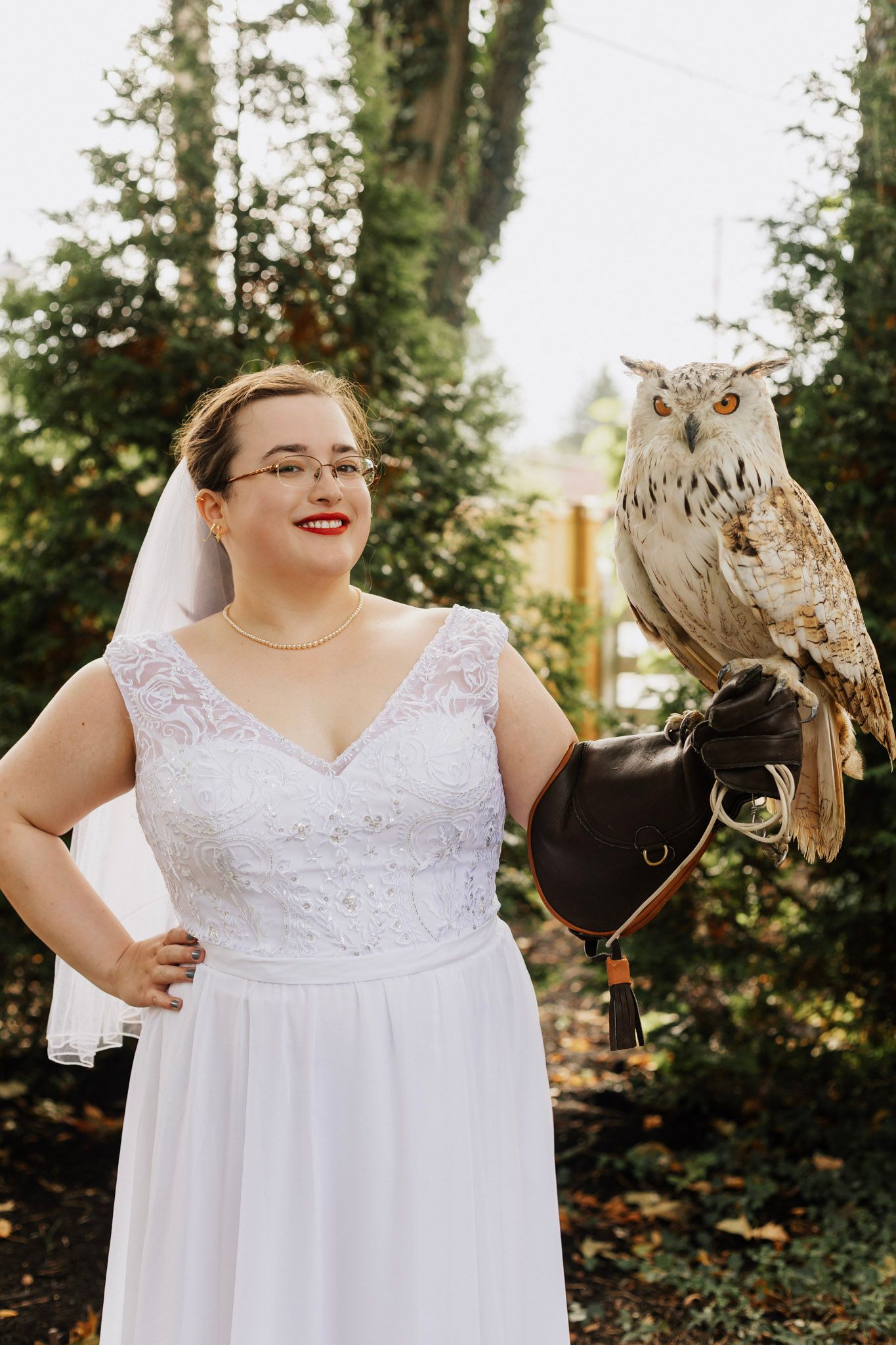 A white owl poses with wedding party members outdoors during a special ceremony moment.