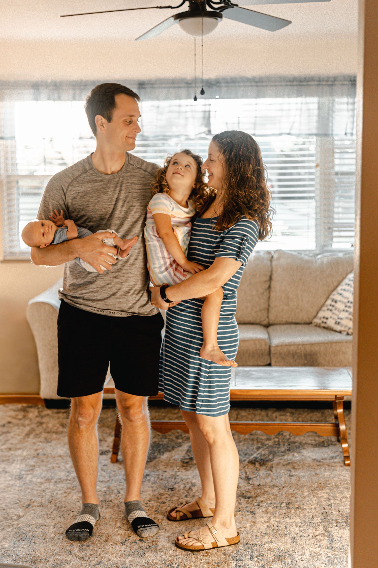Family sharing playful dance moves together in their living room.