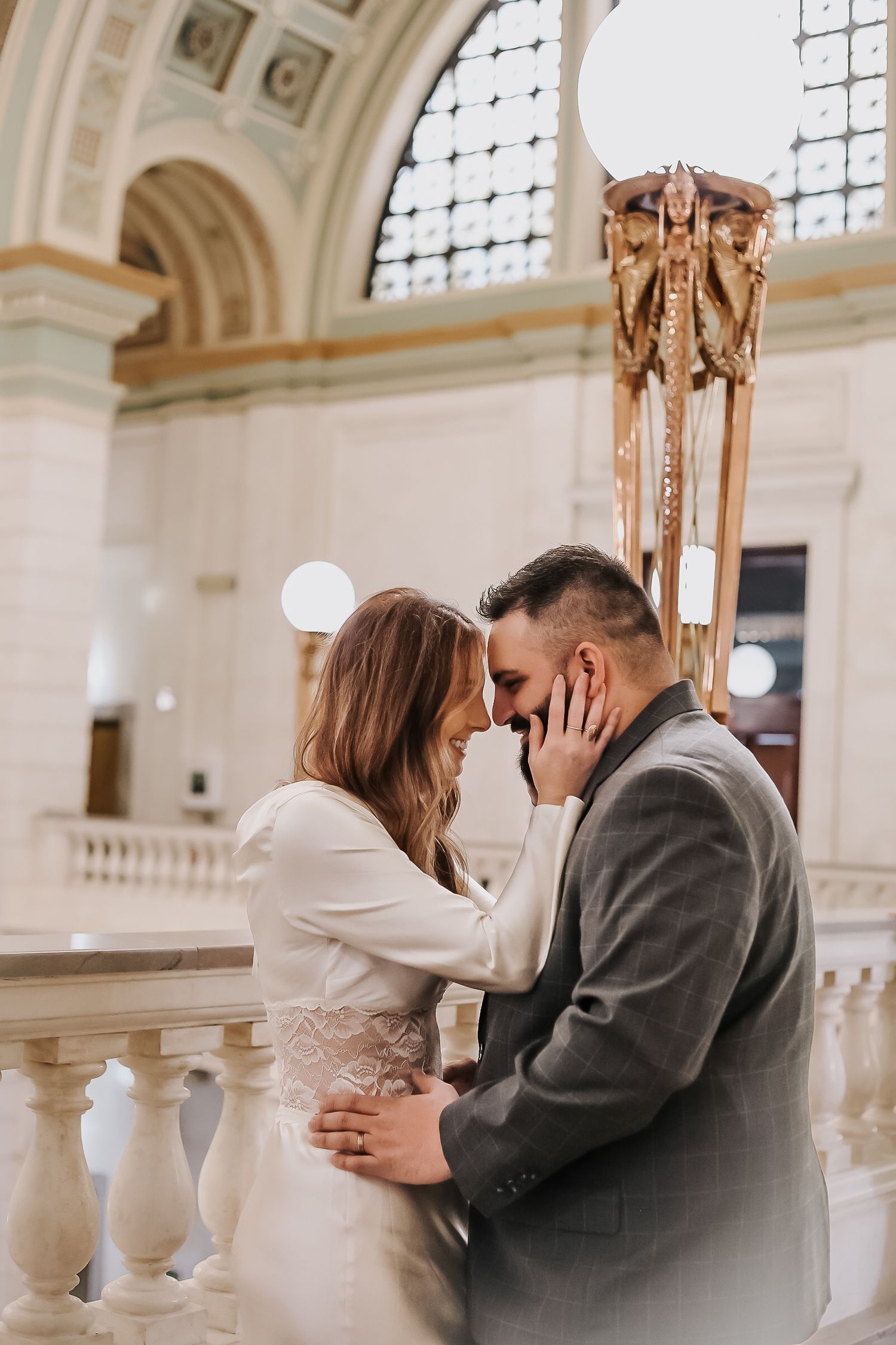 Intimate wedding moments captured in historic building with ornate architecture.