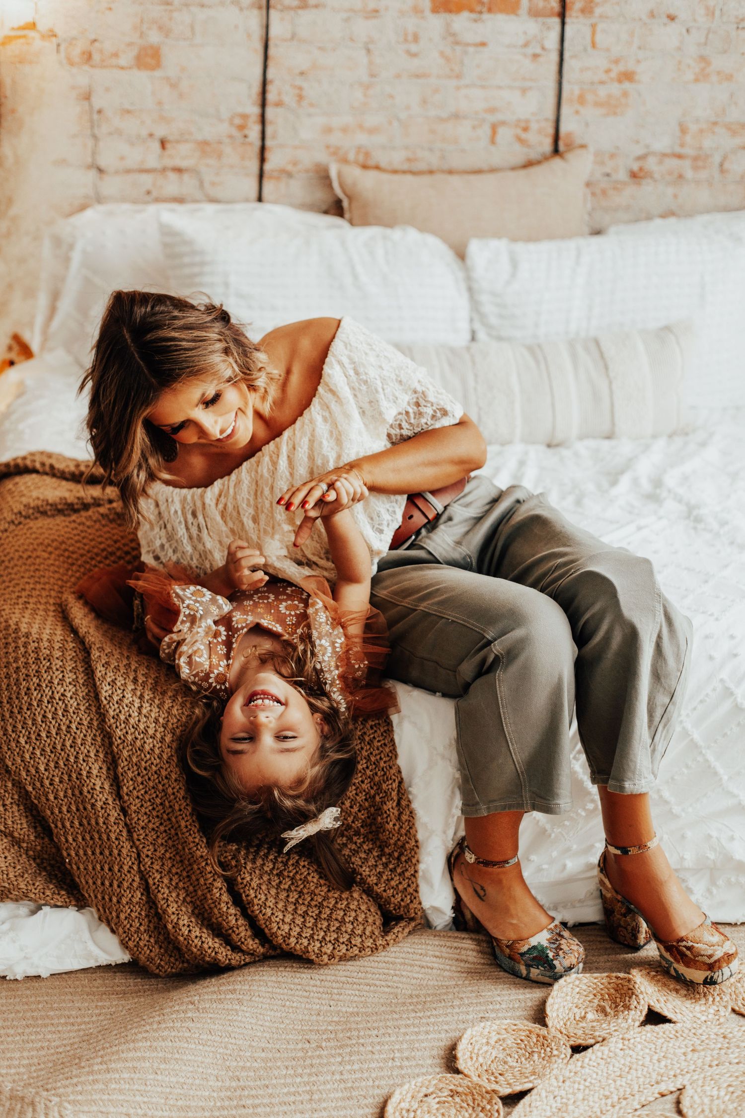 Candid moment captured on white bedding with natural window light.