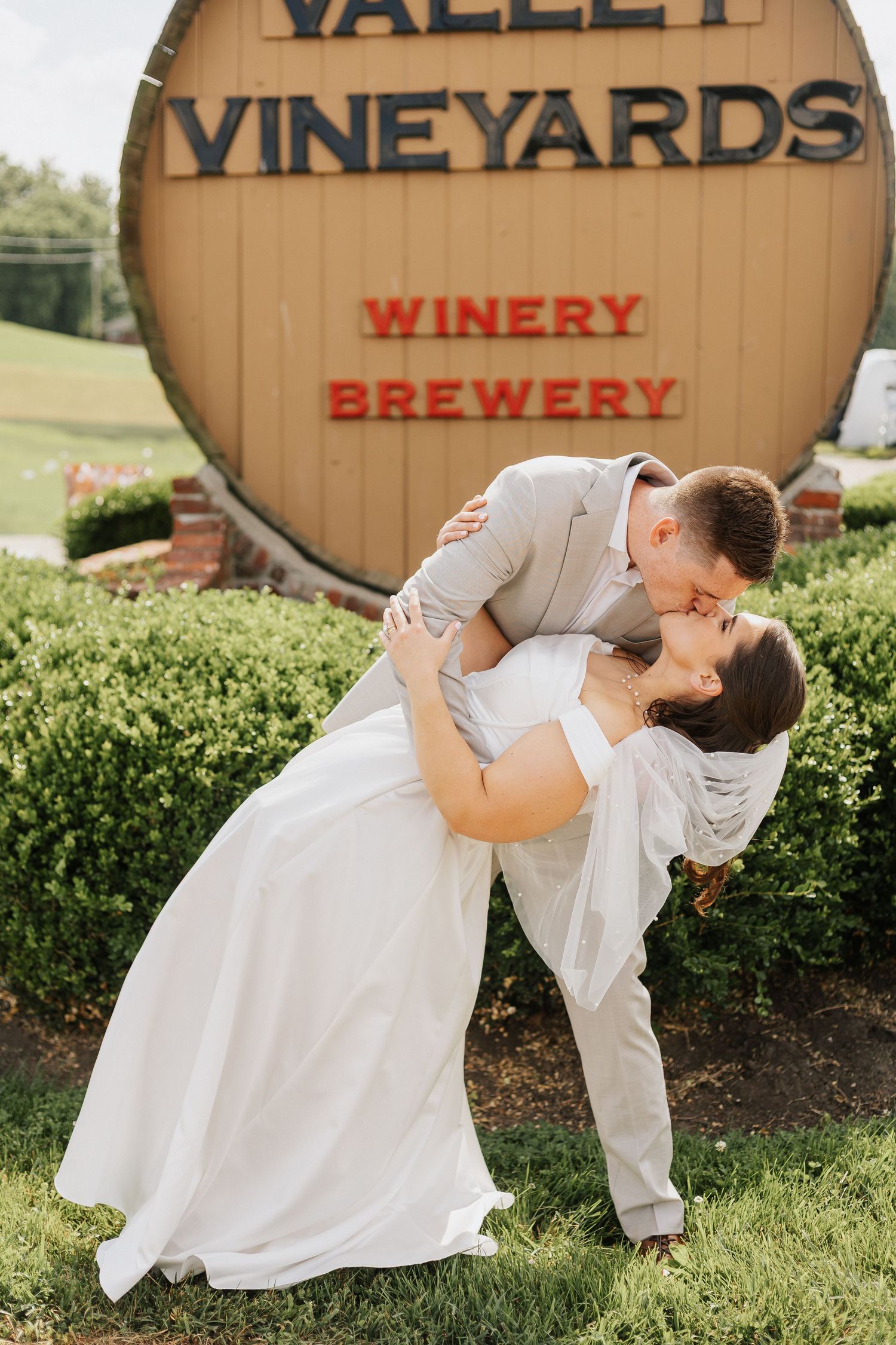 Romantic wedding photo series at Valley Vineyards winery showing playful dips and poses.