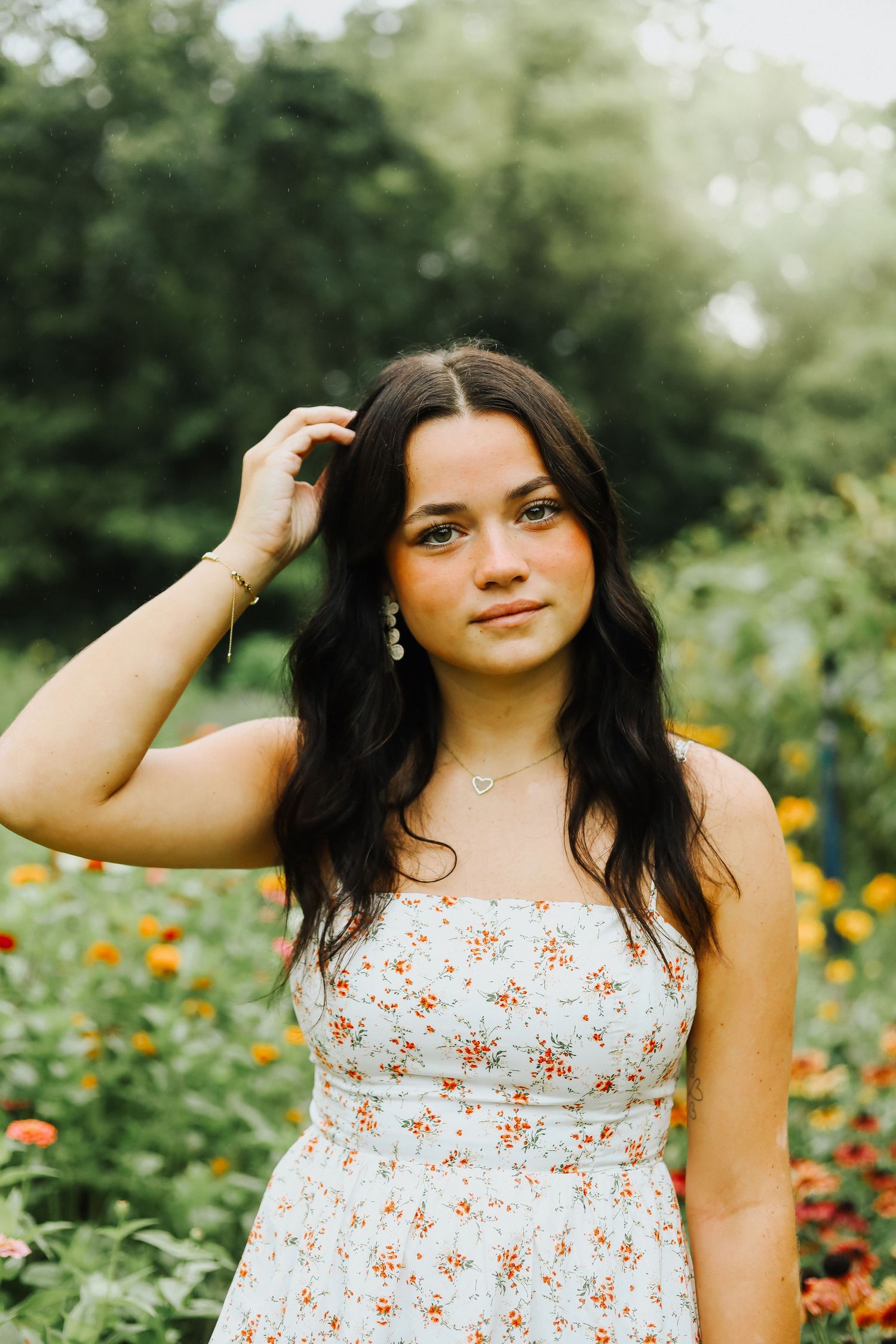 Summer portrait session in a garden featuring a floral sundress among colorful blooms.