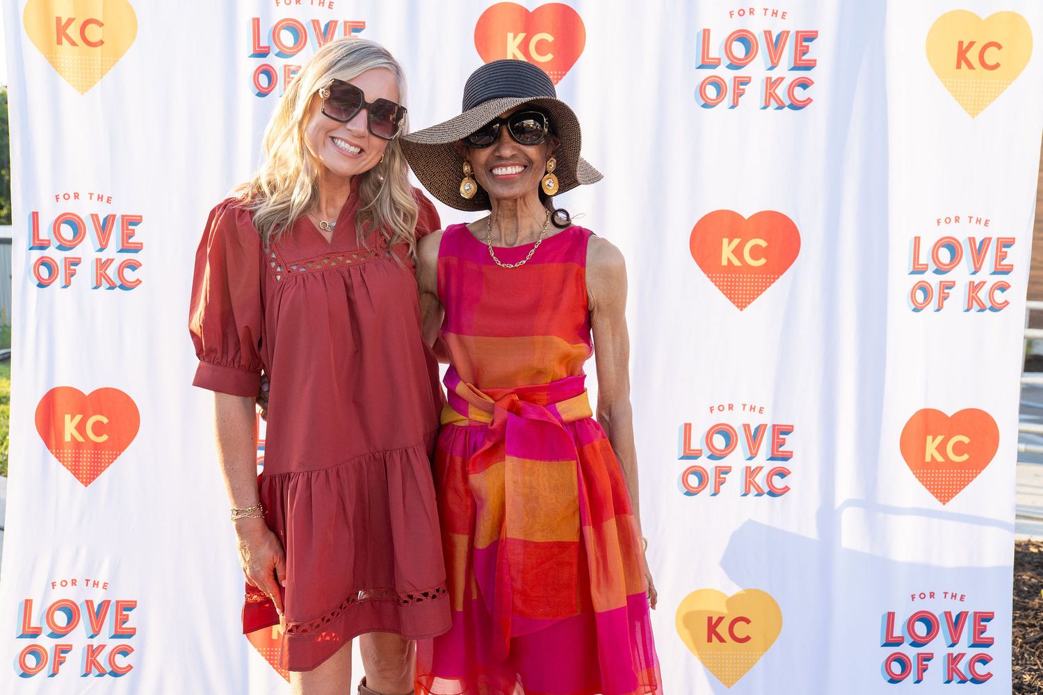 Event backdrop with repeating 'Love KC' hearts and logos for photo opportunities.