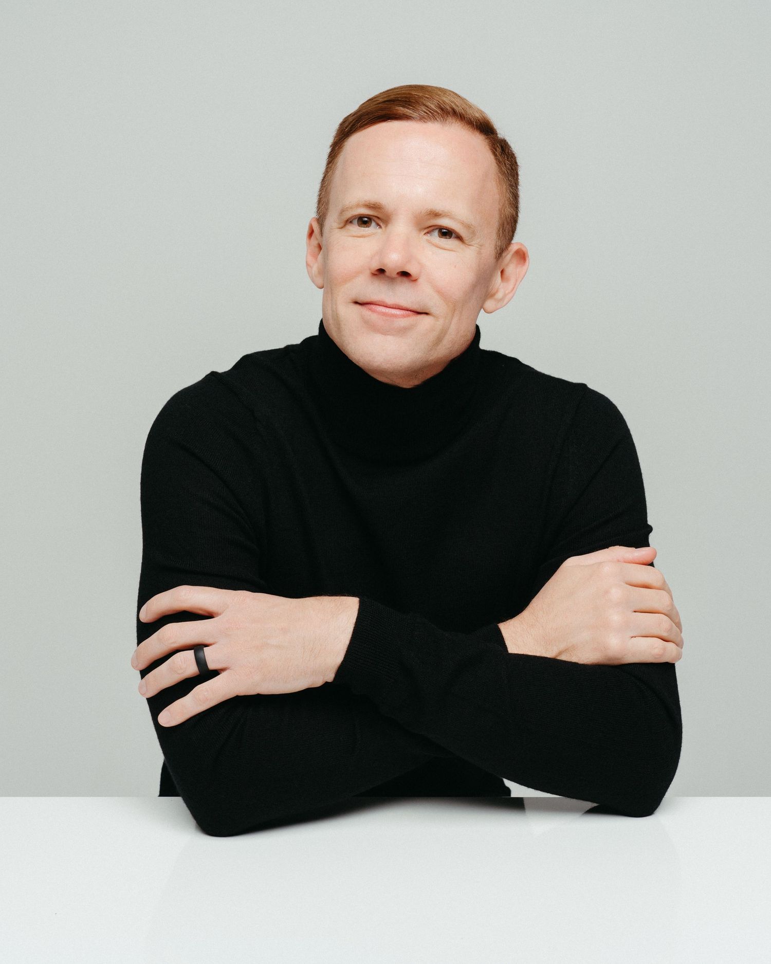 Professional headshots showing a person in a black turtleneck against a light background.