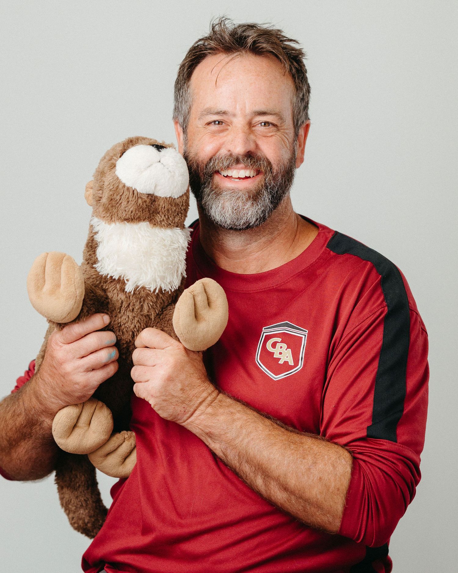 Portrait series with plush monkey toy and red athletic shirt against gray background.