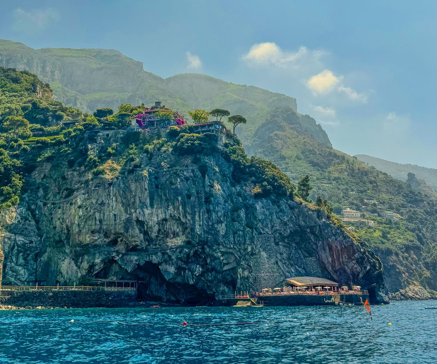 Dramatic cliffside restaurant and villa perched above turquoise waters on the Amalfi Coast, Italy.