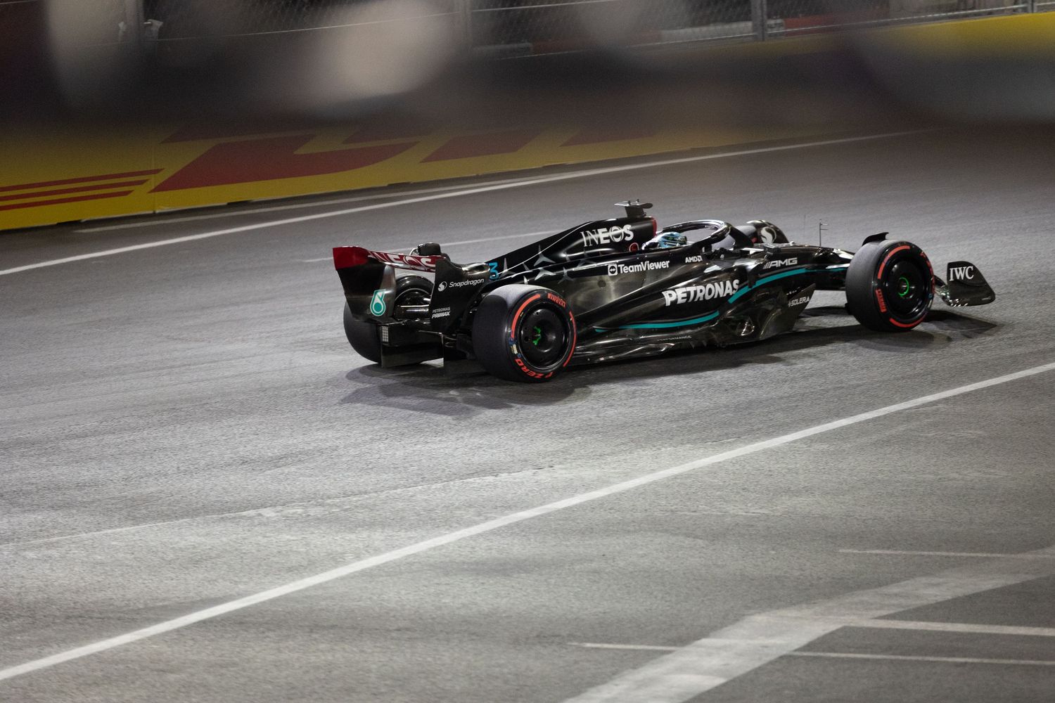 Mercedes AMG F1 car spinning out on wet Las Vegas Grand Prix track at night.