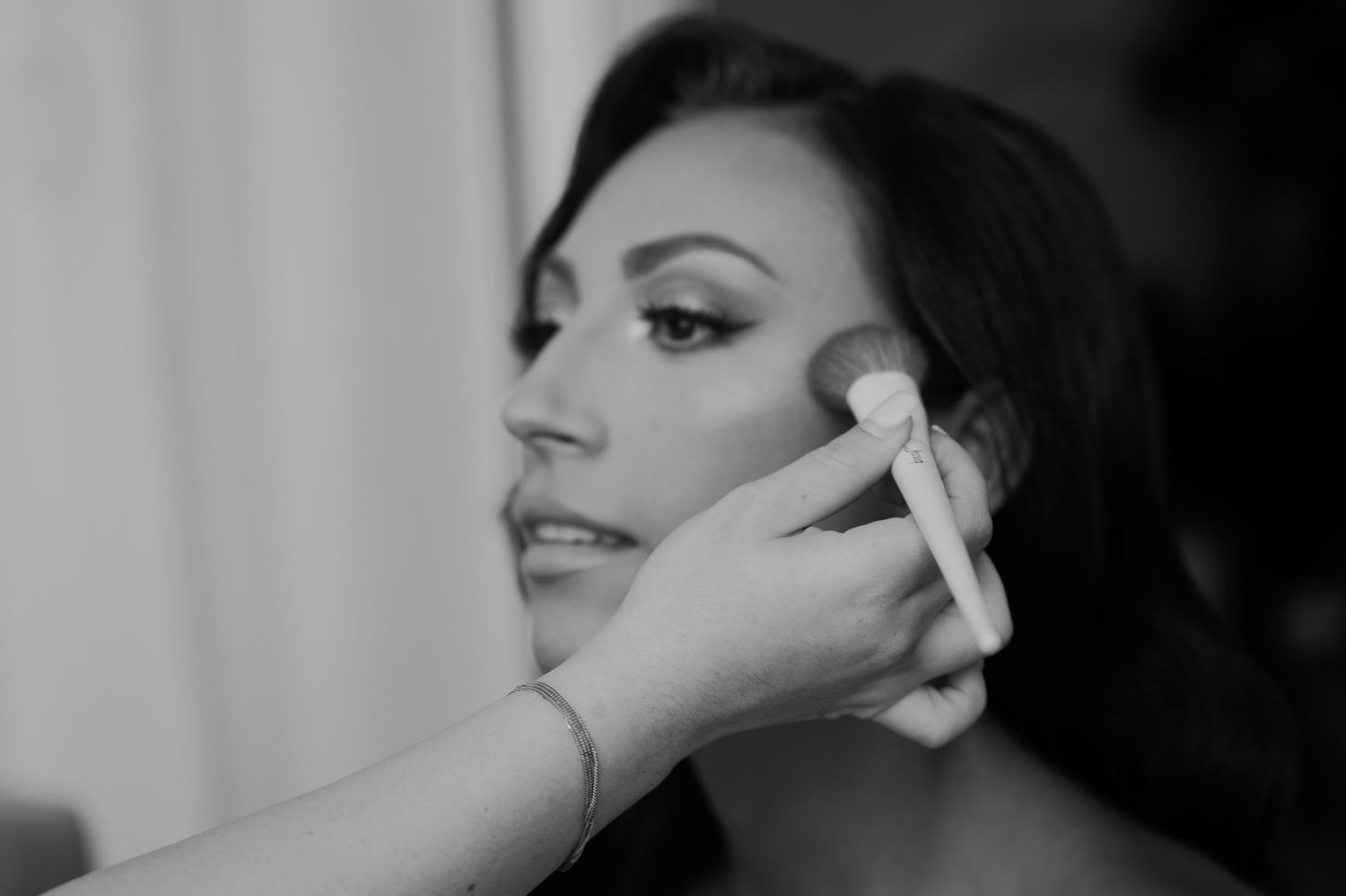 Close-up black and white portrait showing dramatic lighting and elegant makeup.