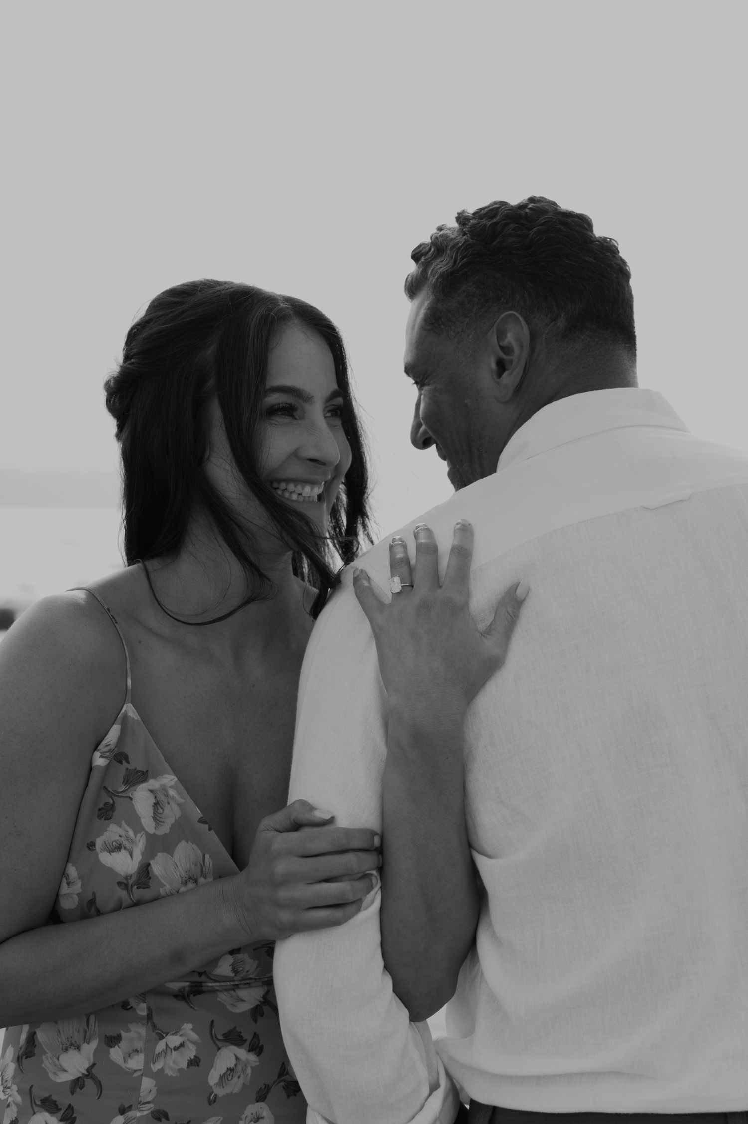 Romantic couple sharing an intimate moment on the beach in black and white.