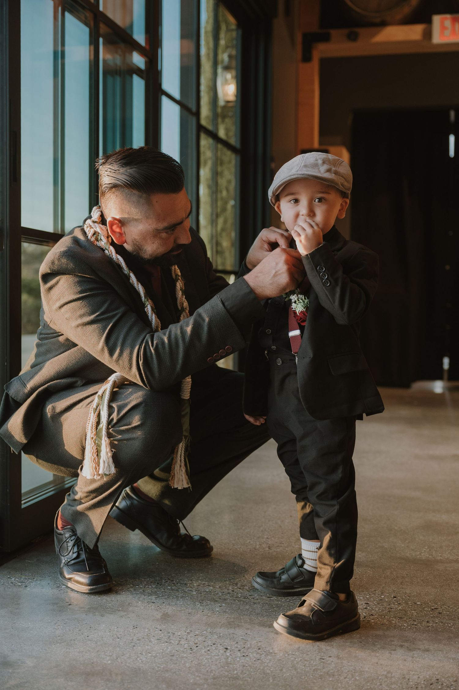 Sequence showing someone in casual wear crouching by large windows.