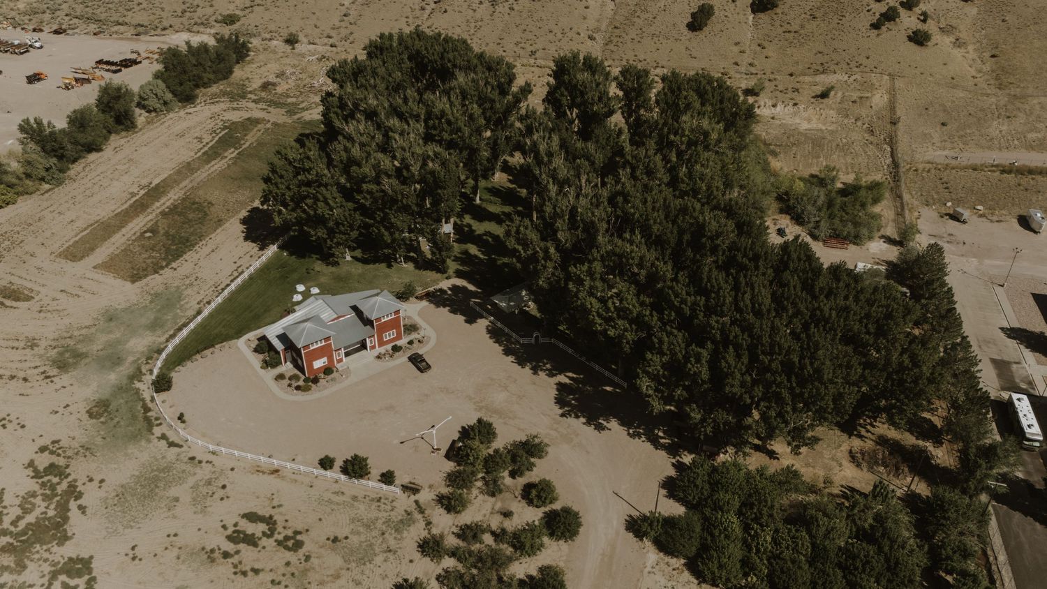 Panoramic view of a rustic outdoor wedding venue with rolling hills in the background.